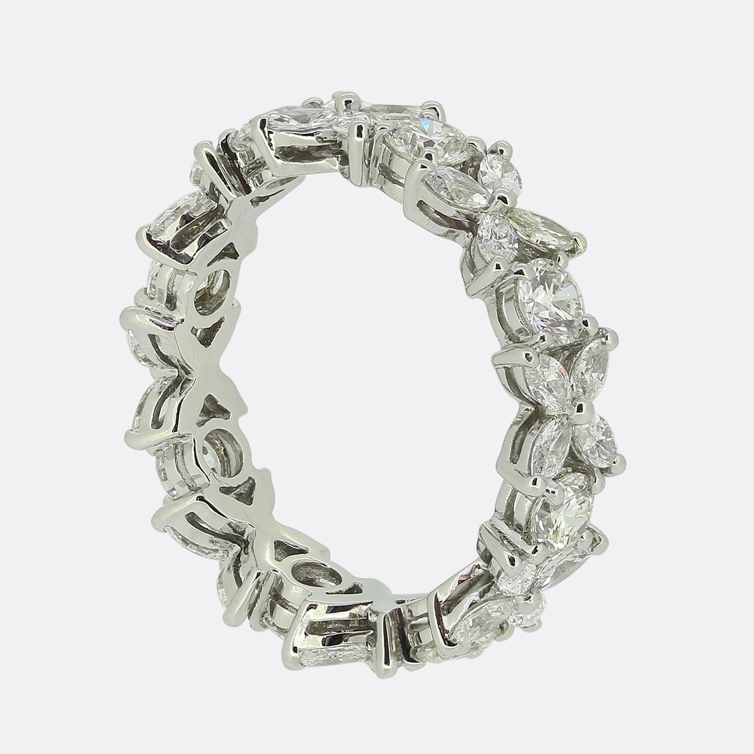 Here we have an outstanding diamond eternity ring from the world renowned jewellery designer, Tiffany & Co. This piece has been crafted from platinum and showcases an alternating sequence of Tiffany's iconic Victoria design consisting of four