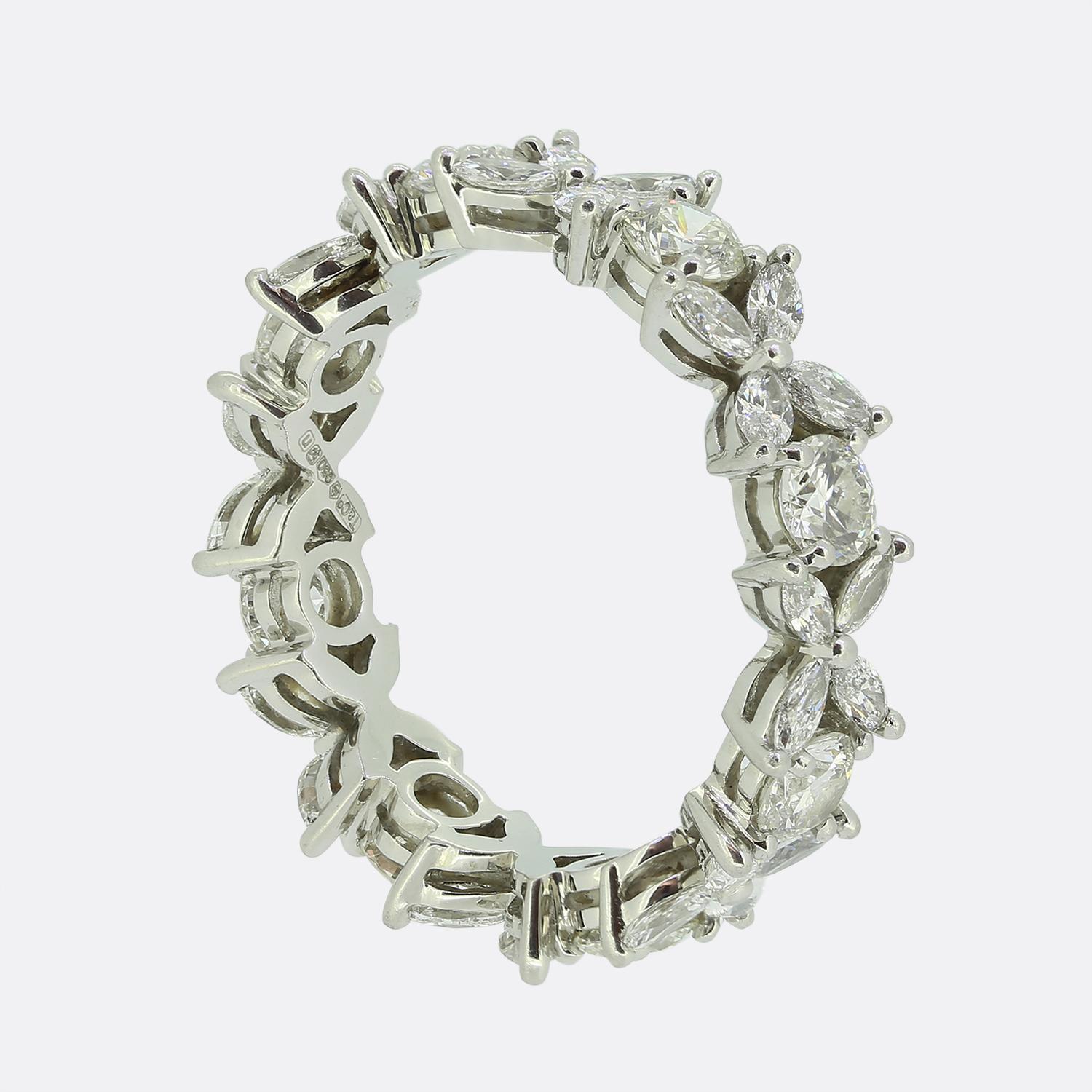 Here we have an outstanding diamond eternity ring from the world renowned jewellery designer, Tiffany & Co. This piece has been crafted from platinum and showcases an alternating sequence of Tiffany's iconic Victoria design consisting of four