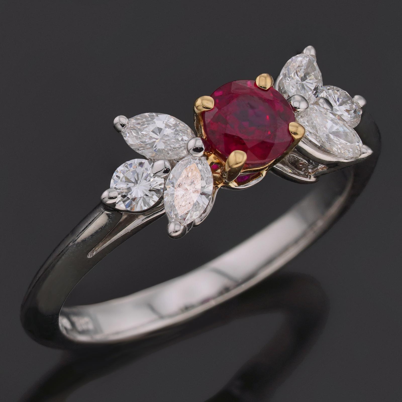 This gorgeous Tiffany & Co. ring from the exquisite Victoria Collection is crafted in platinum and set with a round-cut red ruby and round and marquise-cut F-G-H VVS2-VS1 brilliant-cut round diamonds weighing an estimated 0.50 carats. Made in United