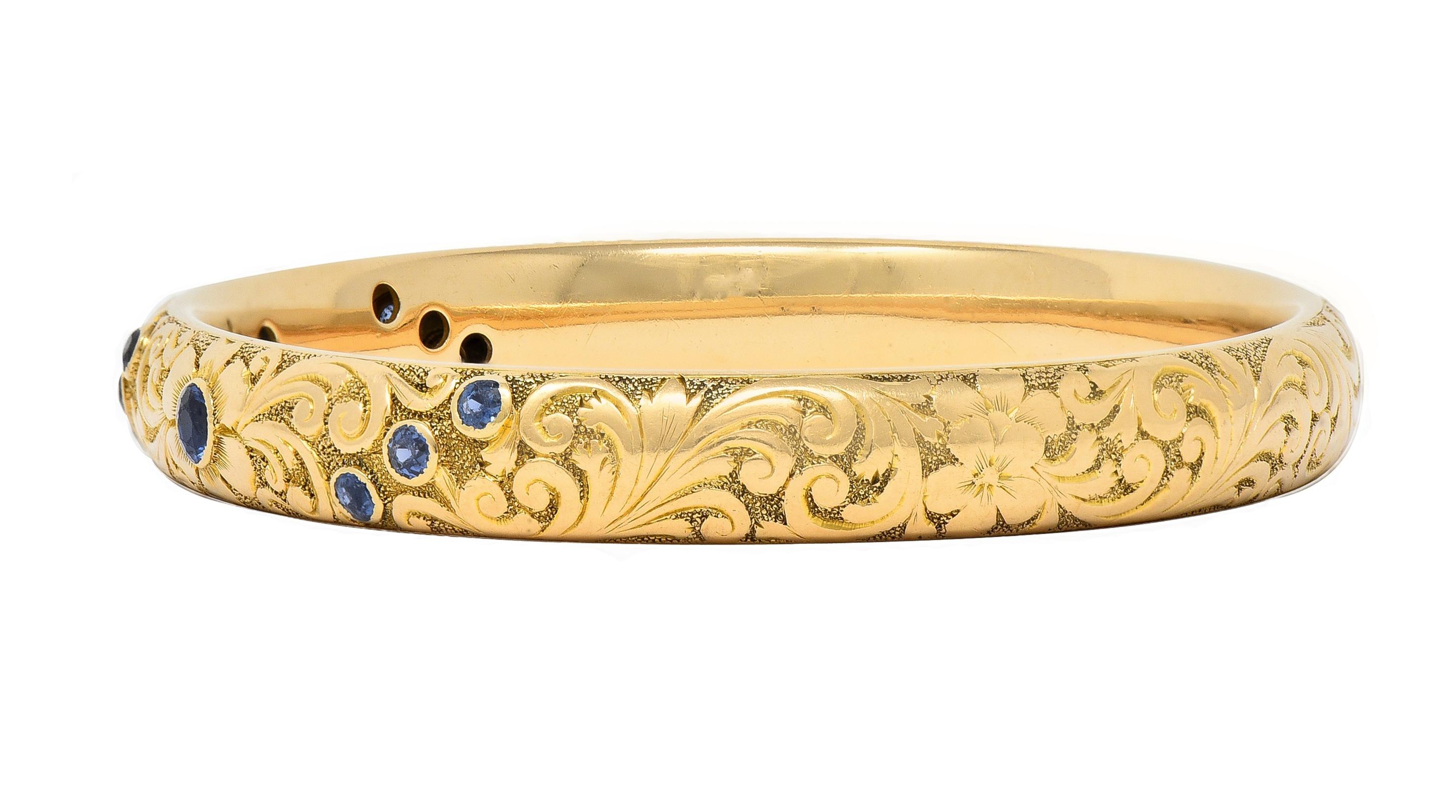 Designed as a bangle bracelet featuring round cut sapphires bezel set to front
Weighing approximately 1.70 carats total - transparent medium blue in color
With engraved scrolling pattern throughout
Accented by orange blossom flowers
Stamped for 14