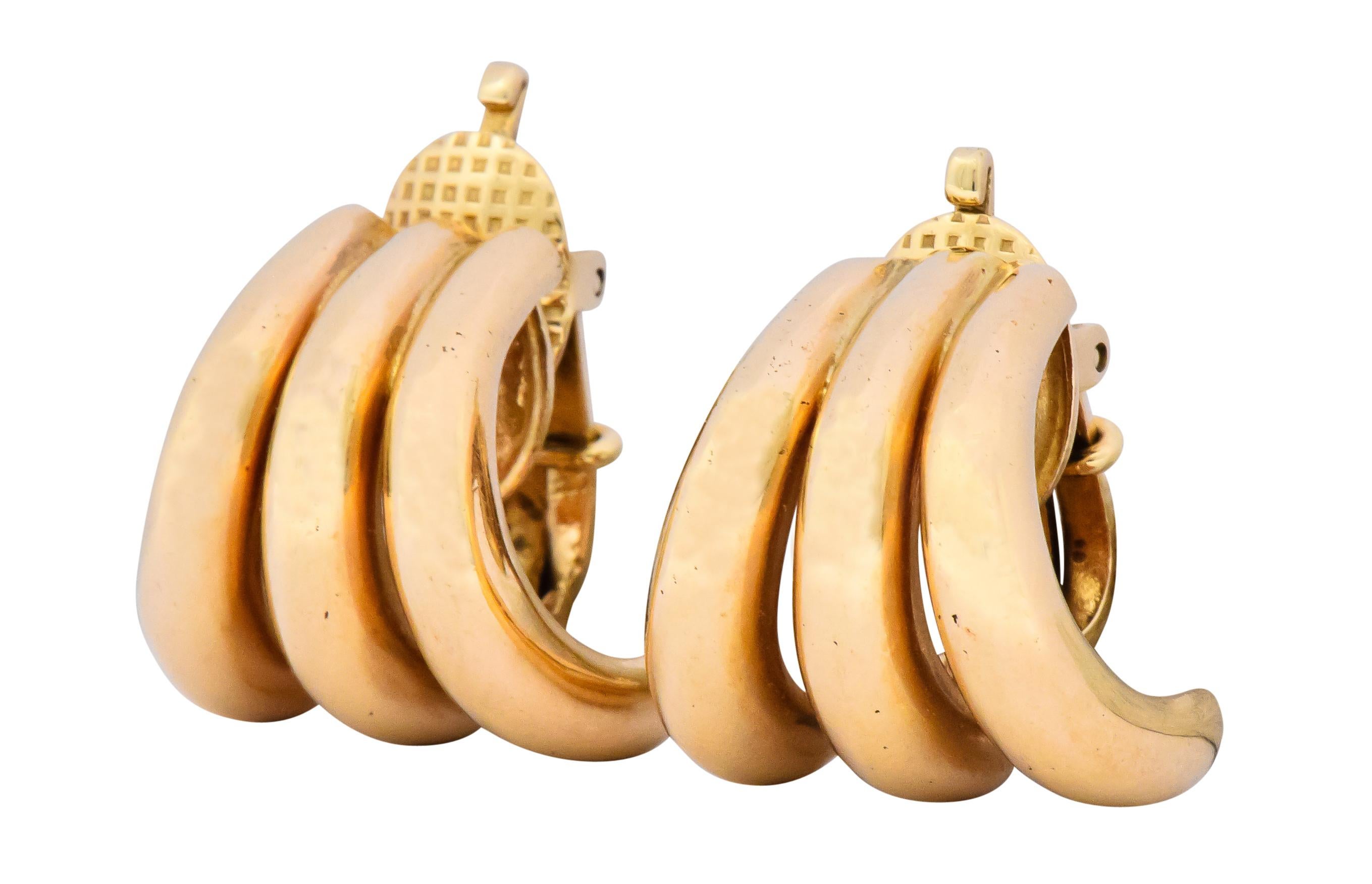 Each designed with three conjoined domed curvatures in a high polished J hoop style

Completed by hinged clip backs

Fully signed Tiffany & Co. and numbered with stamp for 14 karat gold

Measures: approx. 3/4 x 11/16 inch

Total weight: 14.2
