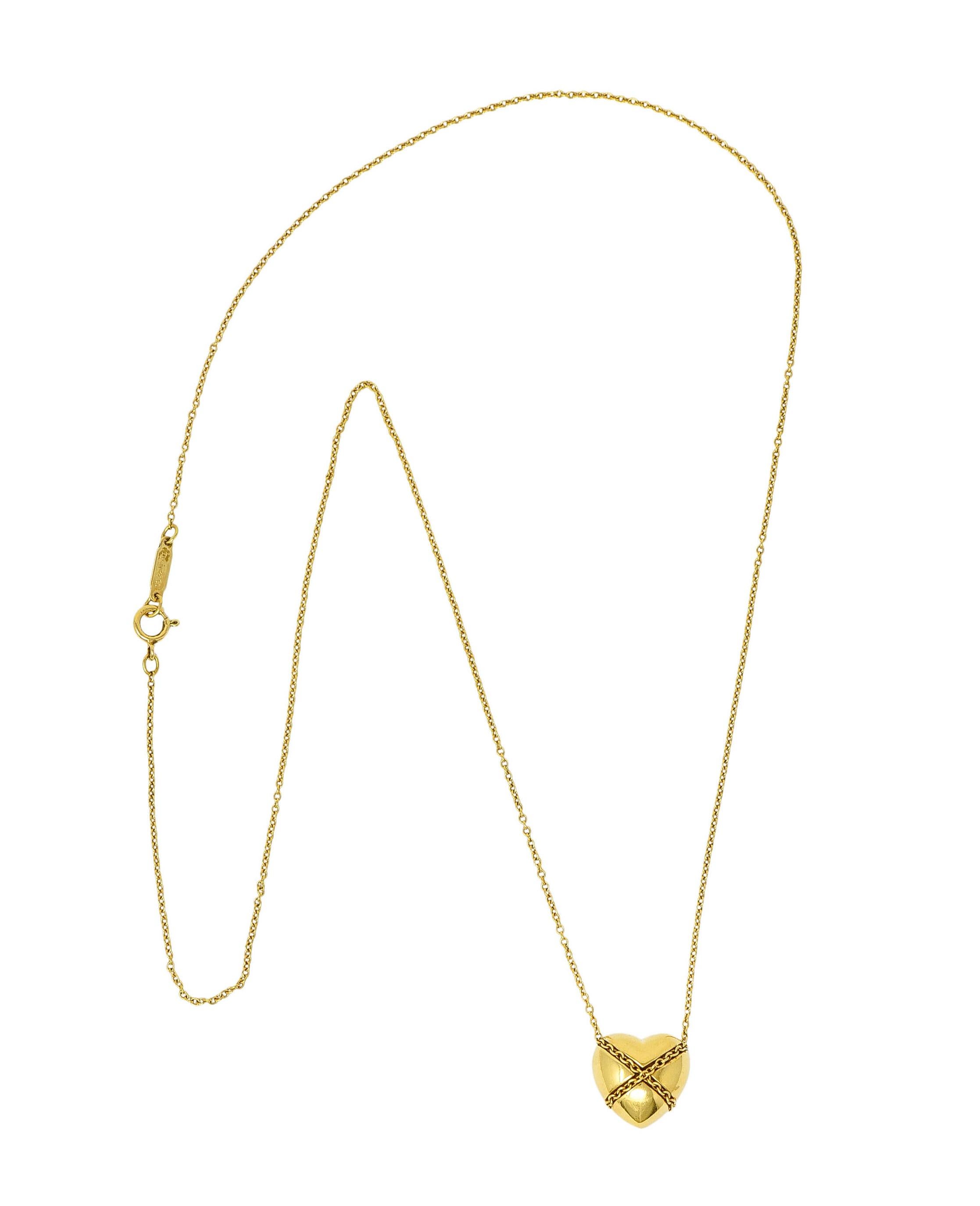 Cable chain necklace suspends a brightly polished puffed heart pendant

Encompassed with a twisted rope motif in a harlequin pattern

Completed by a spring ring clasp

Both stamped 750 for 18 karat gold

Both fully signed Tiffany & Co.

From the