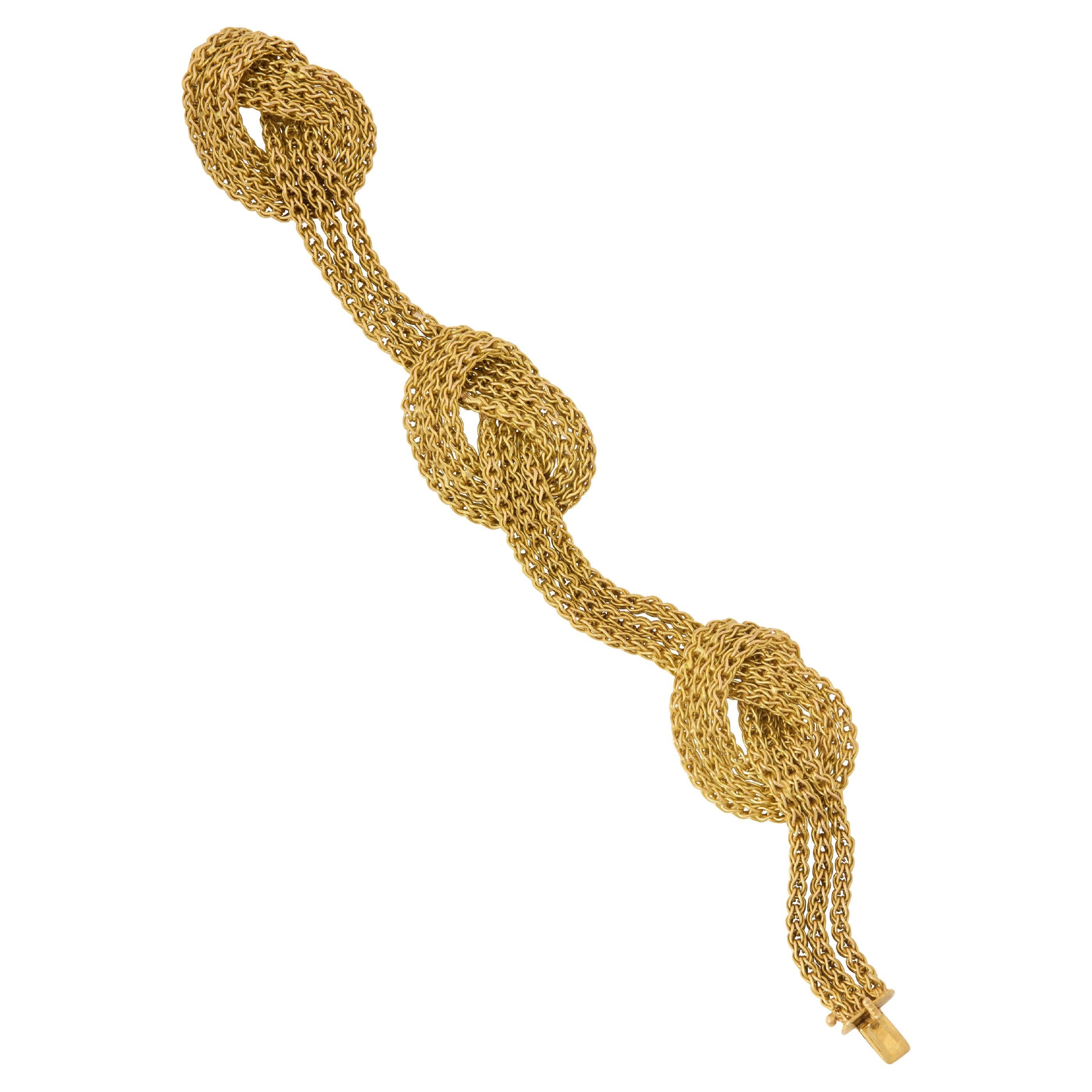 This glamorous 1950s 18-karat yellow gold knotted bracelet by Tiffany & Co. weighs 62.97 grams and measures 8 inches in length. It exudes classic mid-century glamour, whether worn alone as a bold centerpiece or layered with other bracelets for a