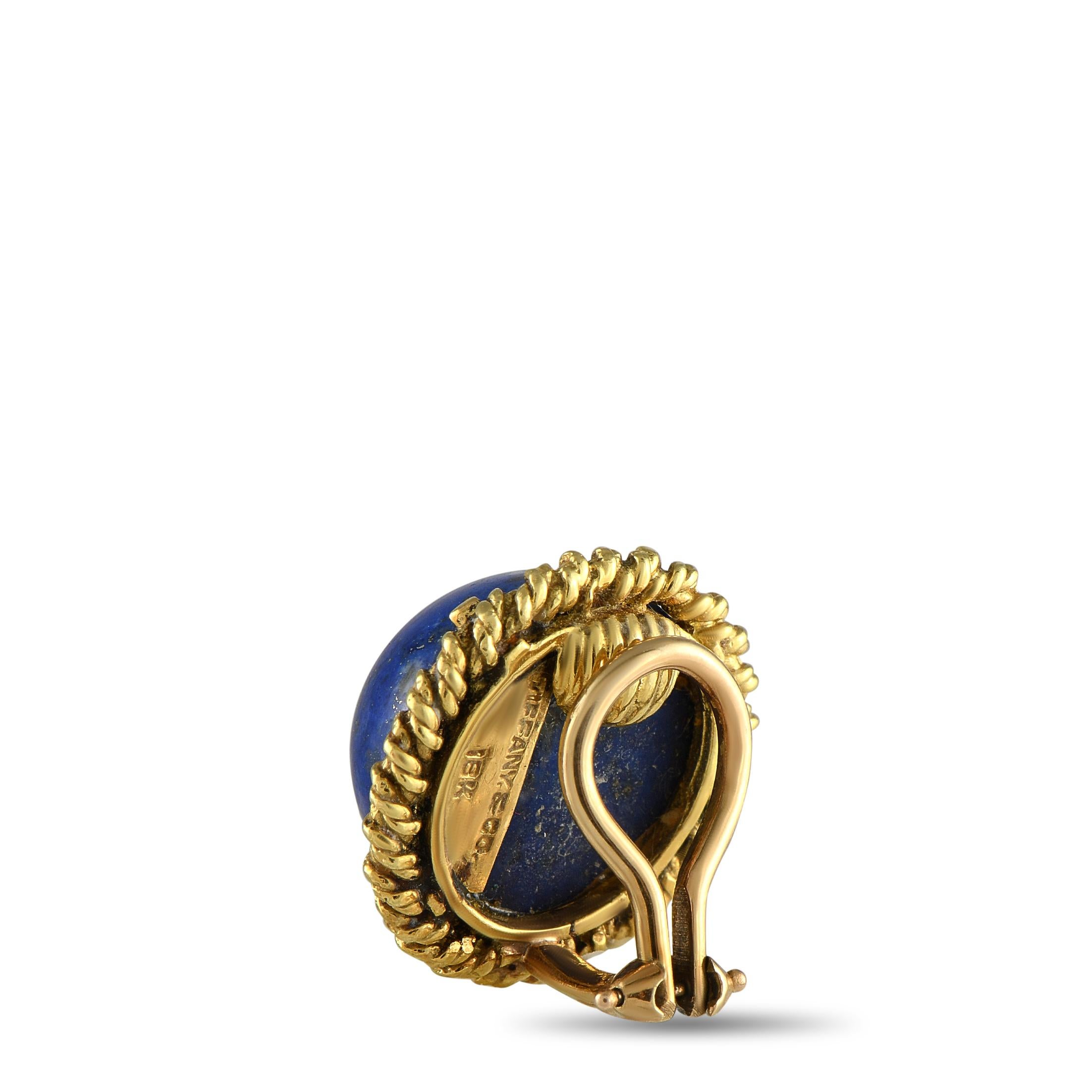 Stunning Lapis stones make a statement at the center of these impeccably crafted Tiffany & Co. earrings. Set in 18K Yellow Gold, the textured setting surrounds the center stone and adds a touch of extra luxury. Each one measures 0.75 round and comes