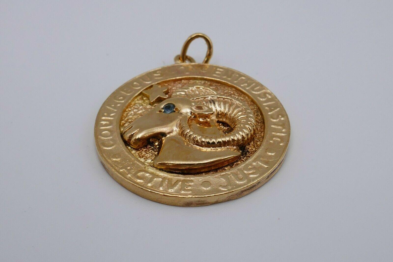Aries Zodiac sign pendant by Tiffany & Co. made of 14k (tested) yellow gold. The Aries' eye is accented with aquamarine. The writing on the edge says: 