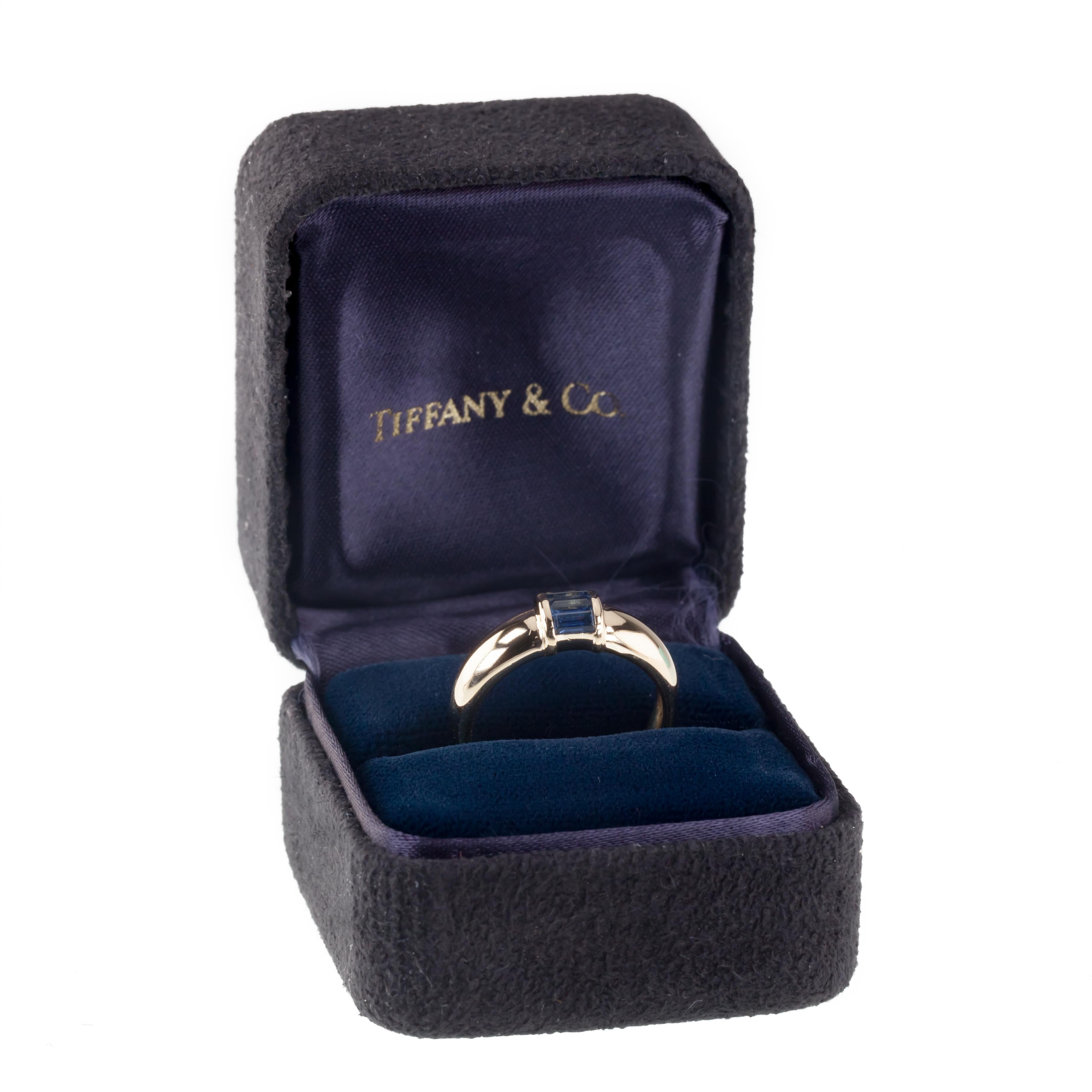 Gorgeous Designer Ring von Tiffany & Co. 
Features Single Bulging Row of Channel-Set Baguette Cut Sapphires
Total Sapphire Gewicht = Appx 0::50 cts
Breite des Rings auf der Vorderseite = 6 mm
Größe 6::5
Gesamtmasse = 4::9 Gramm
Inklusive Original