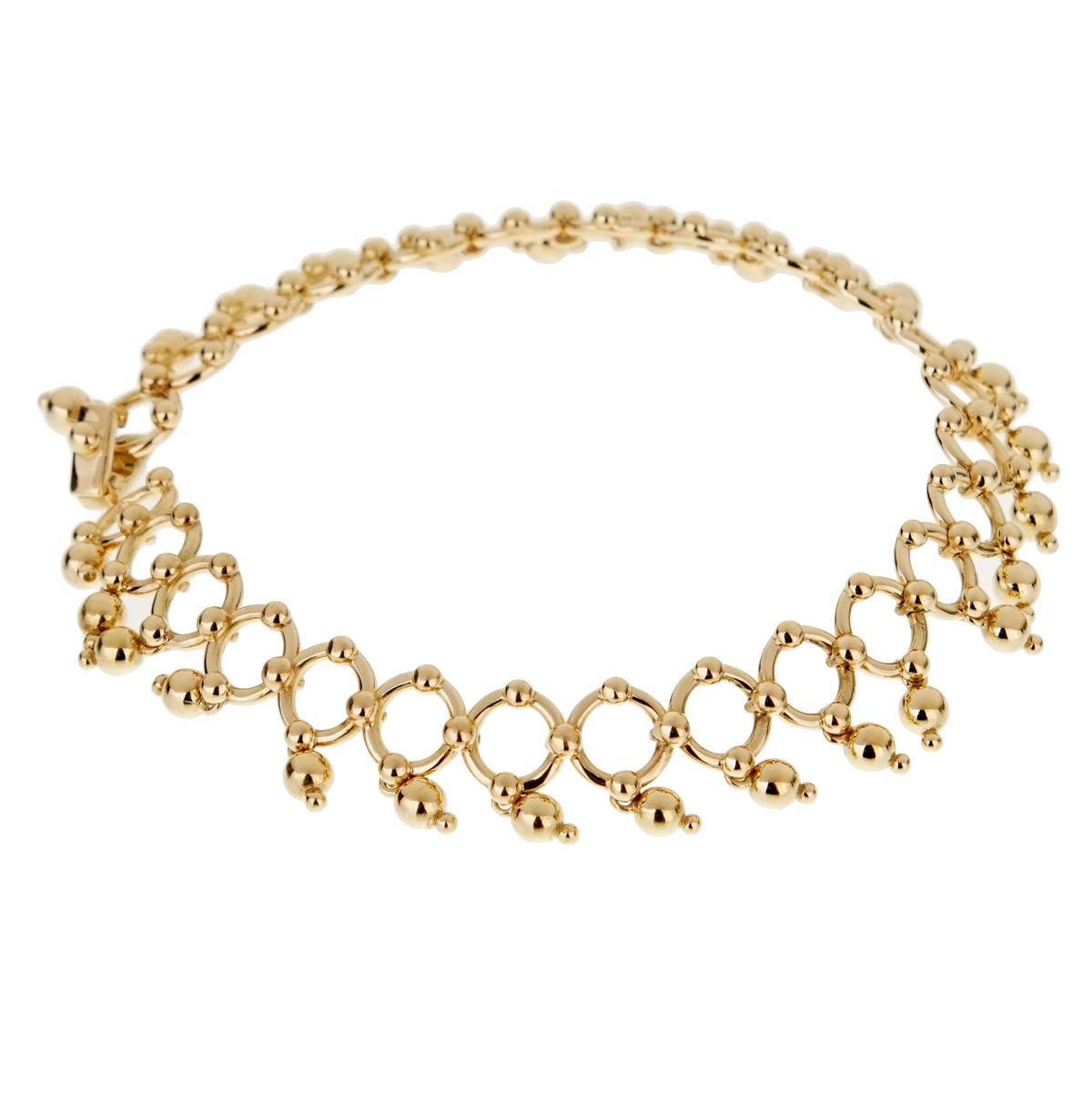 A fabulous 18k yellow gold bracelet by Tiffany & Co featuring round links with dangling 18k beads.
