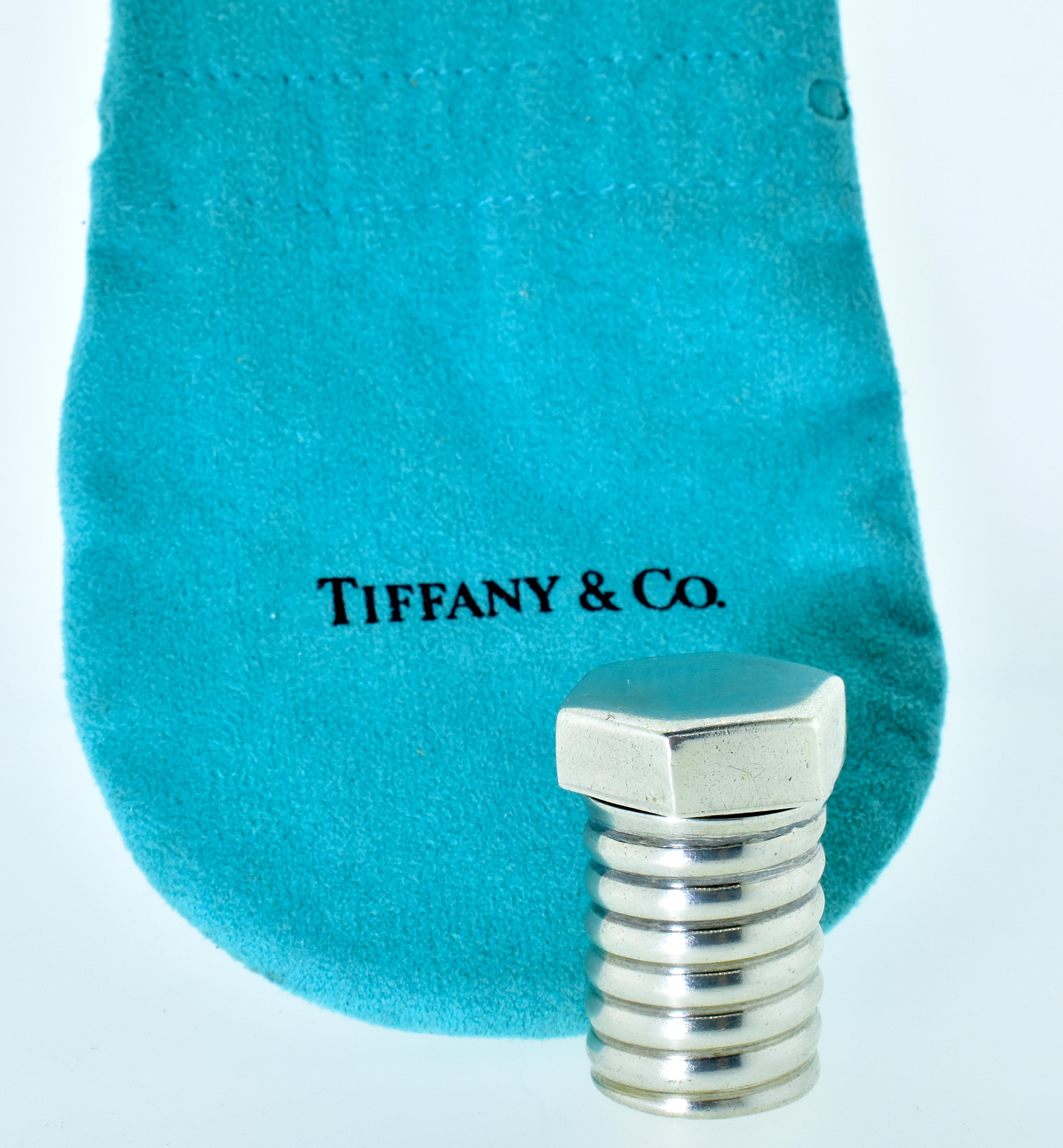 Tiffany & Co. sterling with an interior gold wash small pill holder in a screw/bolt motif.  This vintage object is 1 3/8th inches tall.  The top screws off and on and is meant to hold anything one wants, it is an unusual vintage Tiffany sterling
