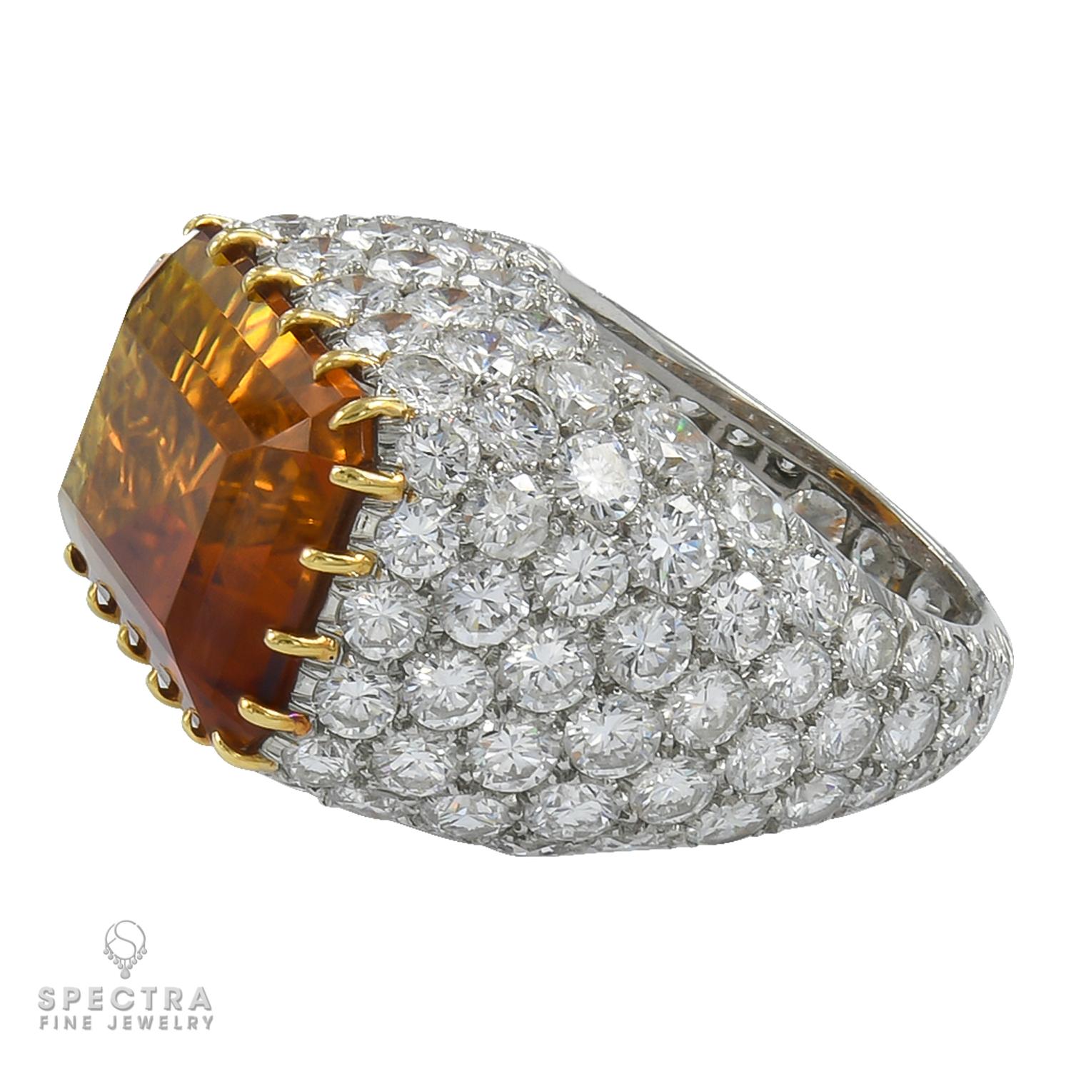 This Tiffany & Co. Vintage Citrine Diamond Cocktail Bombé Ring, crafted in platinum circa 1980s, exudes bold elegance. The emerald-cut citrine, set horizontally, glows with a golden honey hue amidst sparkling white diamonds in a domed bombé design.
