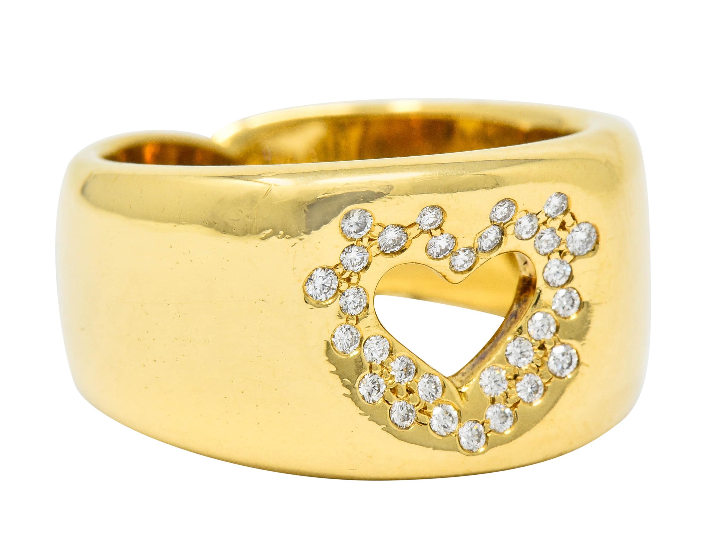 Wide band ring centering a pierced heart motif

Sprinkled with flush set diamonds weighing approximately 0.30 carat; eye-clean and white

Completed by a sweet shank detail at base

Fully signed Tiffany & Co. and stamped 750 for 18 karat gold

Circa: