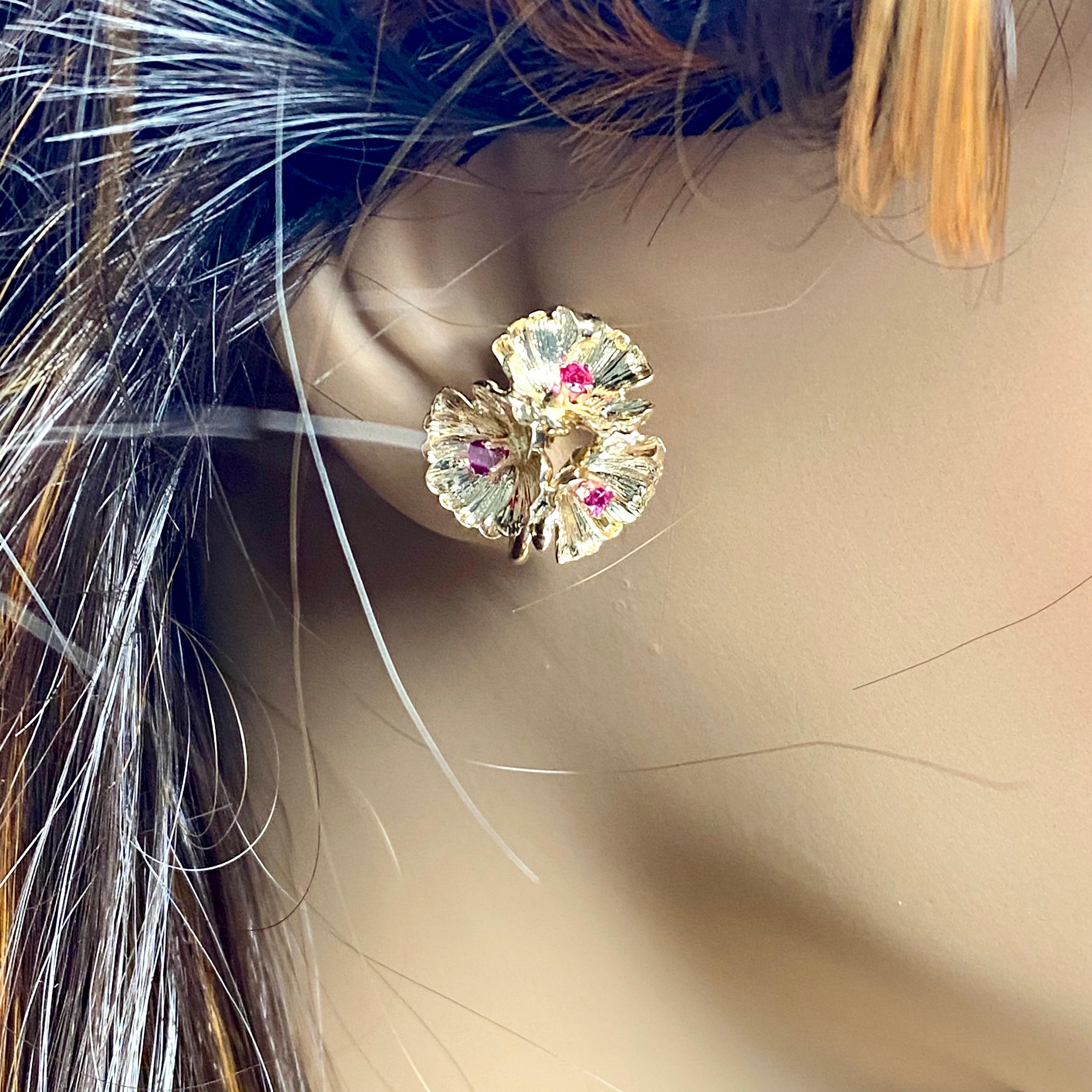 The Tiffany and Co 14 Karat Yellow Gold Ruby Clip on Vintage Dogwood Blossoms Earrings are a beautiful and timeless piece of jewelry that is perfect for any occasion. These earrings are made of 18k yellow gold and feature round rubies in a simple,
