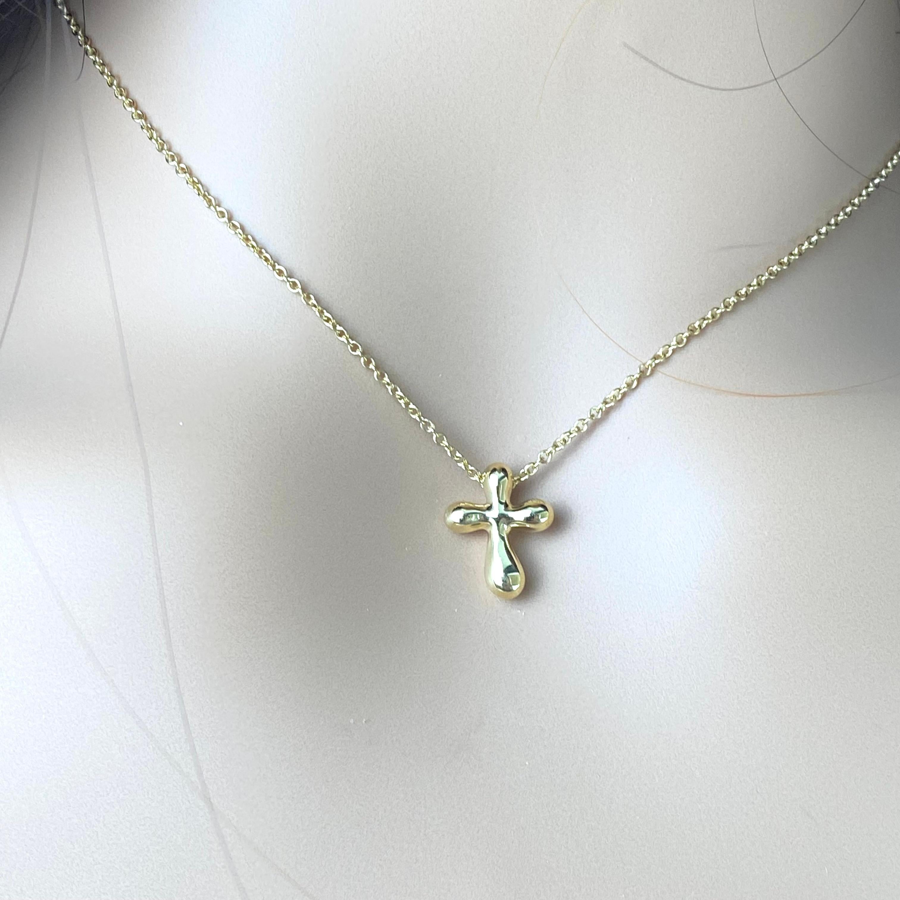 Add a touch of timeless elegance to your ensemble with this exquisite Tiffany & Co Elsa Peretti Cross Pendant Necklace. Crafted from luxurious 18 karat yellow gold, this necklace is a symbol of both faith and sophistication.
The pendant features a