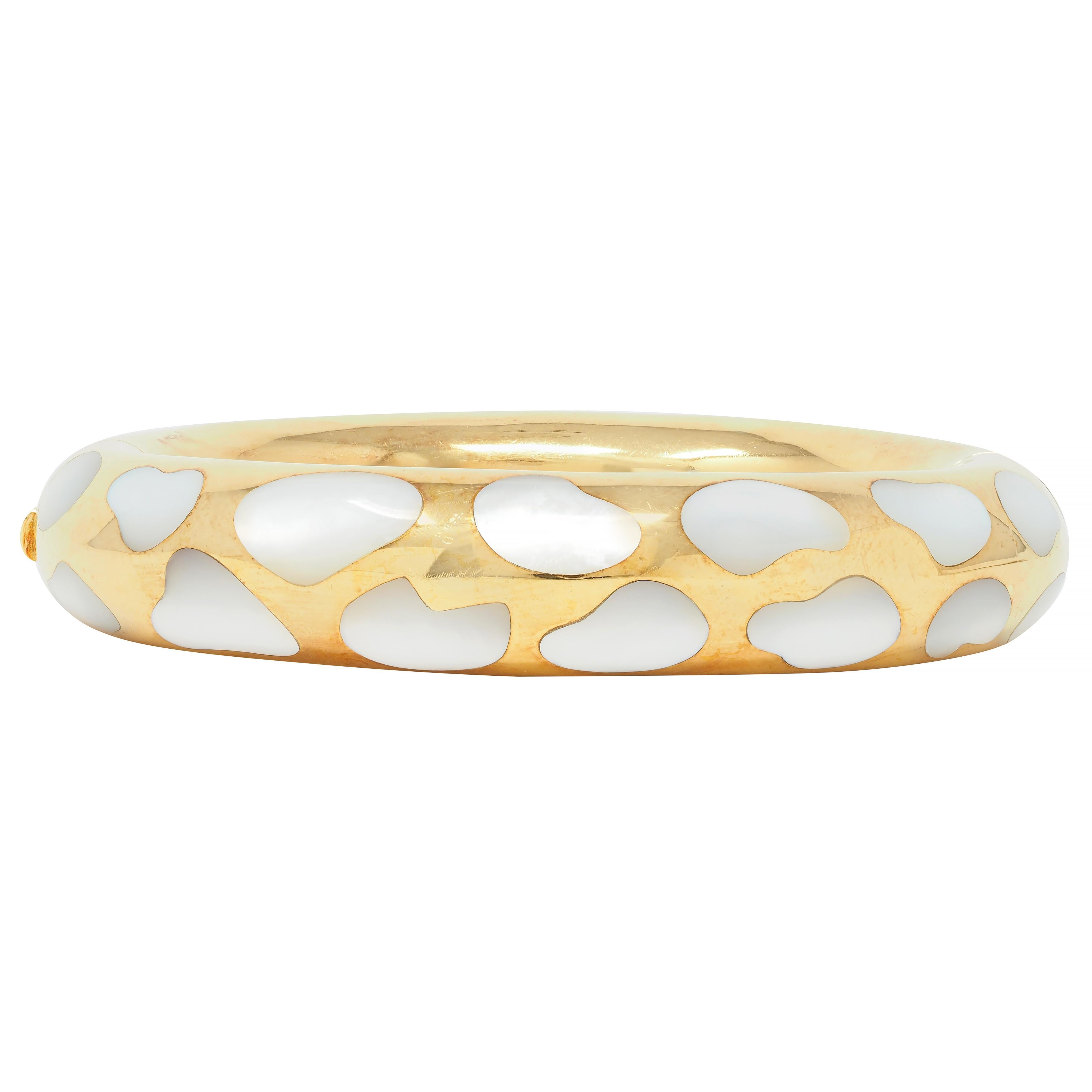 Designed as a rounded yellow gold bangle inlaid with mother-of-pearl
Organically shaped and ranging in size 
White with strong iridescence 
With high polish finish
Opens on a hinge via press release clasp 
Stamped for 18 karat gold
Fully signed for