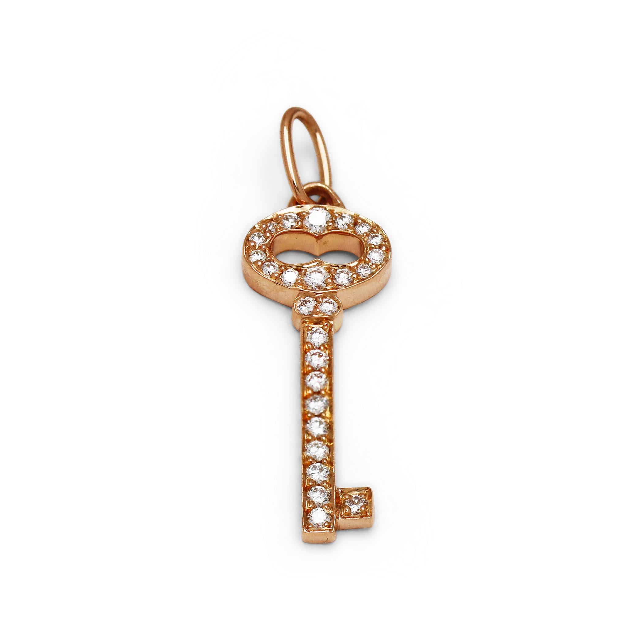 Authentic Tiffany & Co. 'Vintage Oval' key charm crafted in 18 karat rose gold and set with approximately 0.15 carats of round brilliant diamonds. The charm measures 1 inch in length and is accompanied by a black silk cord. Signed Tiffany & Co.,