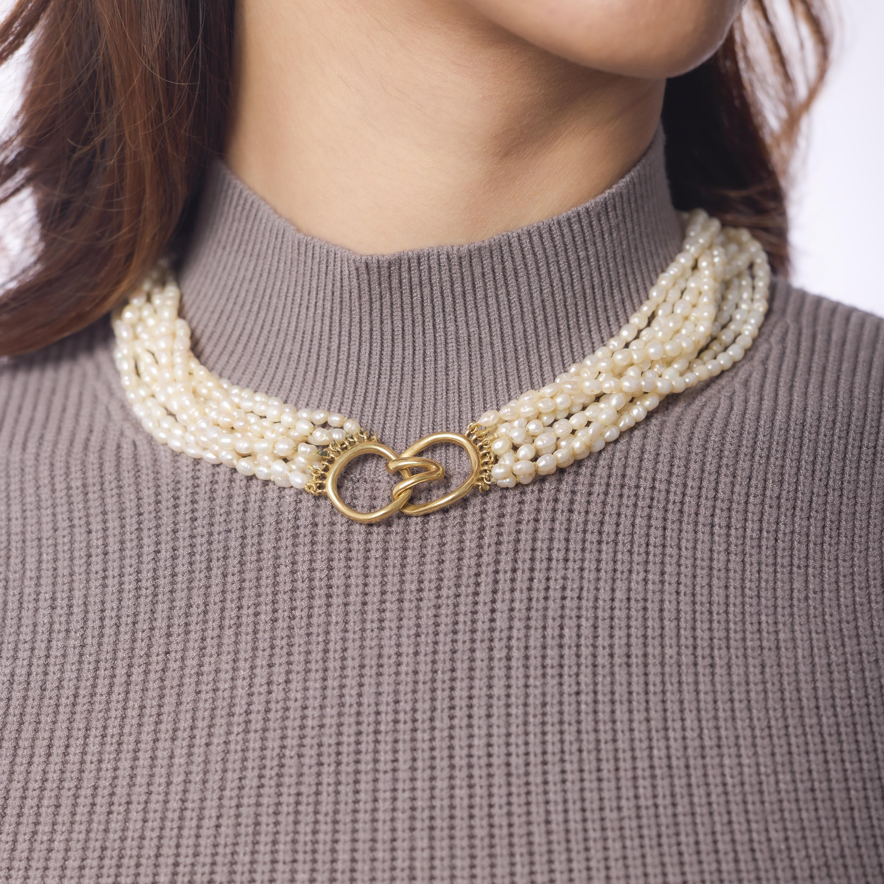 This vintage Tiffany & Co. necklace stuns with ten luminous strands of 5.98mm pearls elegantly gathered by rich 18k yellow gold findings. Crafted in the 1970s, it embodies timeless sophistication with iconic Tiffany elegance—luxurious in presence