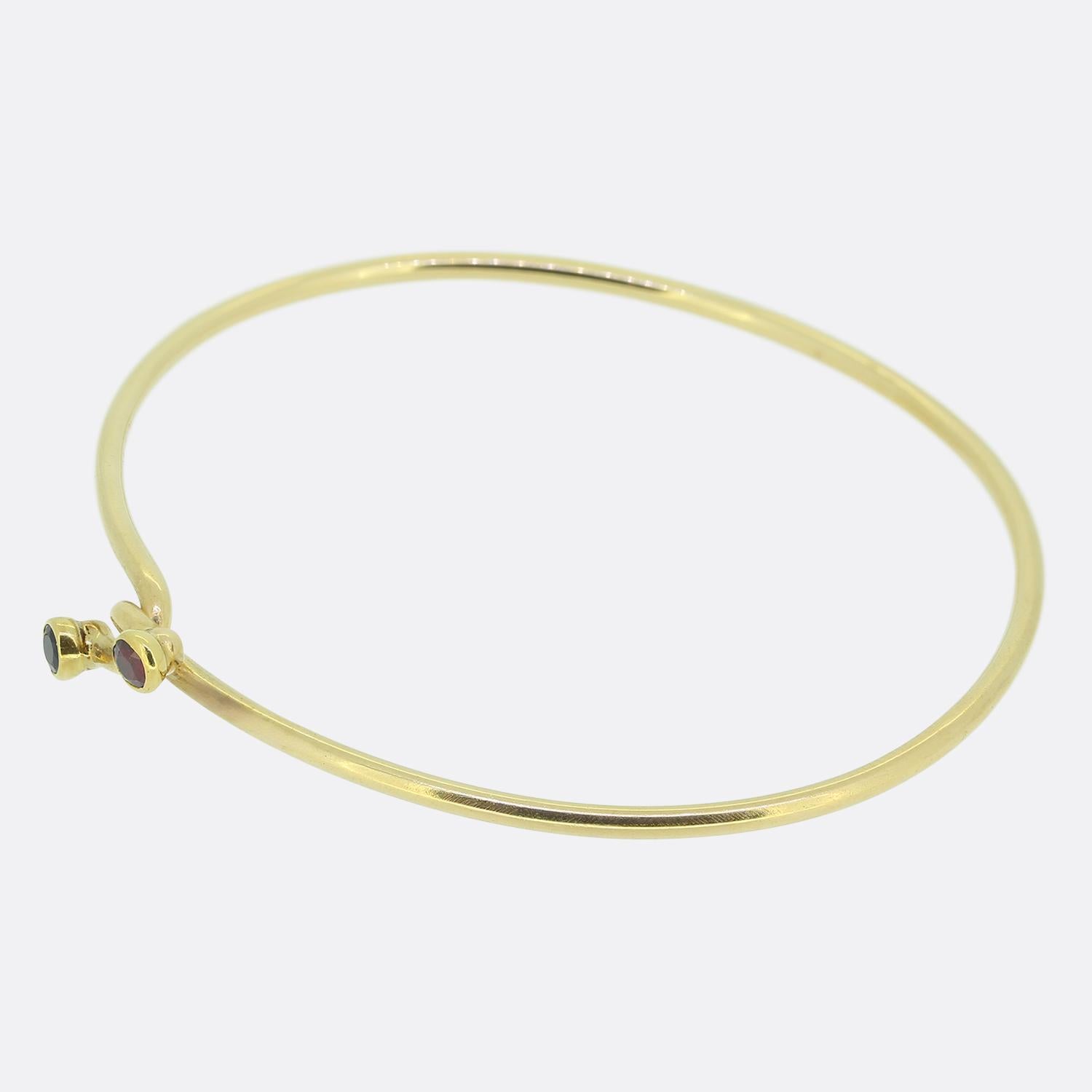 Here we have a vintage and rare bangle from the luxury jewellery designer Tiffany & Co. The bangle is crafted in 14ct yellow gold and features a locking style where both ends secure on each other. One end is set with a ruby and the other a
