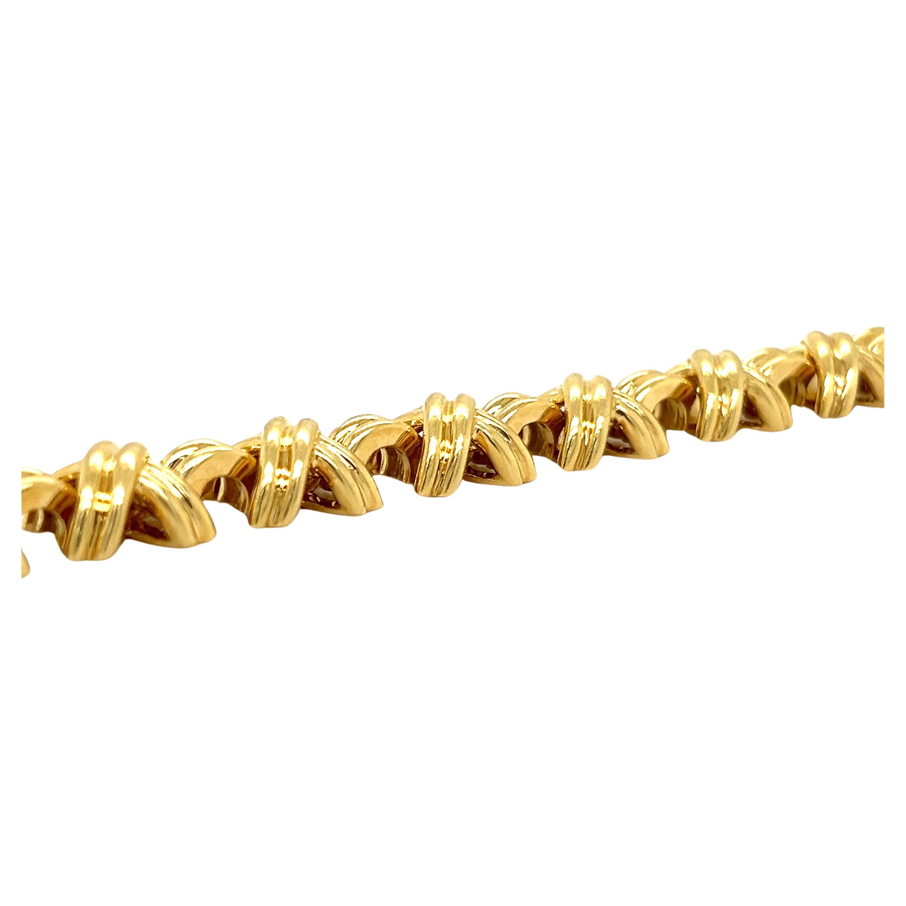 Beautiful bracelet by famed designer Tiffany & Co. the bracelet is crafted in solid 18k yellow gold and is from the X collection. 
   The bracelet shows a 10.75 mm width and weighs 50.8 grams. The bracelet measures 7.5