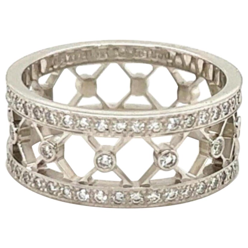 Dieser wunderschöne Ring mit breitem Band ist authentisch aus der Voile Collection'S von Tiffany & Co. Er ist 8 mm breit und hat eine offene Mitte mit X-Design um das gesamte Band. An jedem Ende des Bandes hat einen vollen Kreis von runden