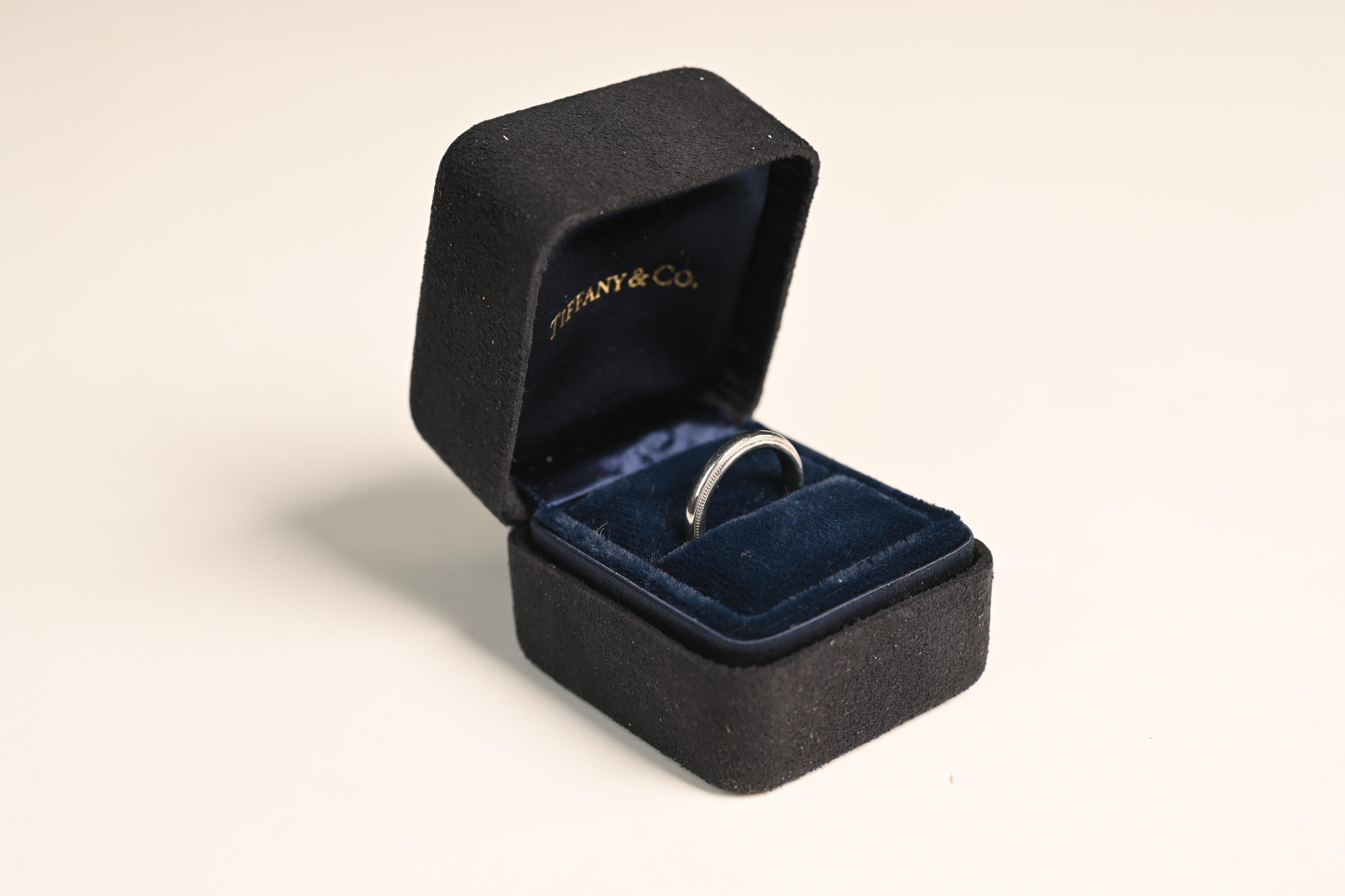 This exquisite Tiffany & Co. platinum wedding band is a timeless symbol of love and commitment, showcasing the brand’s signature craftsmanship and elegance. Meticulously handcrafted, this band features a delicate milgrain edge, a hallmark of