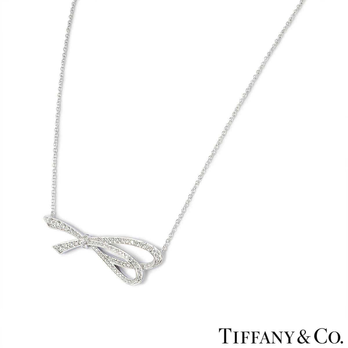 An 18k white gold diamond Bow necklace by Tiffany & Co. The openwork bow motif is set with round brilliant cut diamonds totalling approximately 0.40ct. The bow measures 4cm in width and comes on an original 16 inch chain. The necklace has a gross