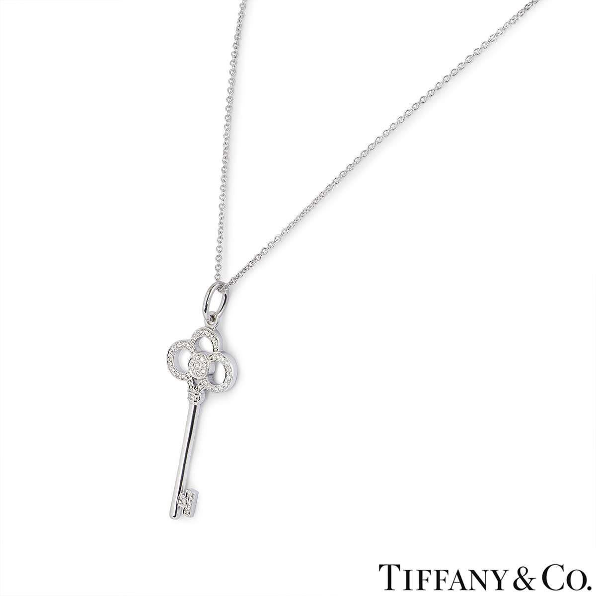 An elegant 18k white gold Crown Key pendant by Tiffany & Co. The pendant features a key motif pave set with round brilliant cut diamonds on the head and tip with a total diamond weight of 0.13ct. The pendant features a loop bail and measures 1.5