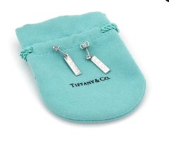 Tiffany & Co. Boucles d'oreilles pendantes en or blanc avec logo Signature et barrette de diamants Or 18K