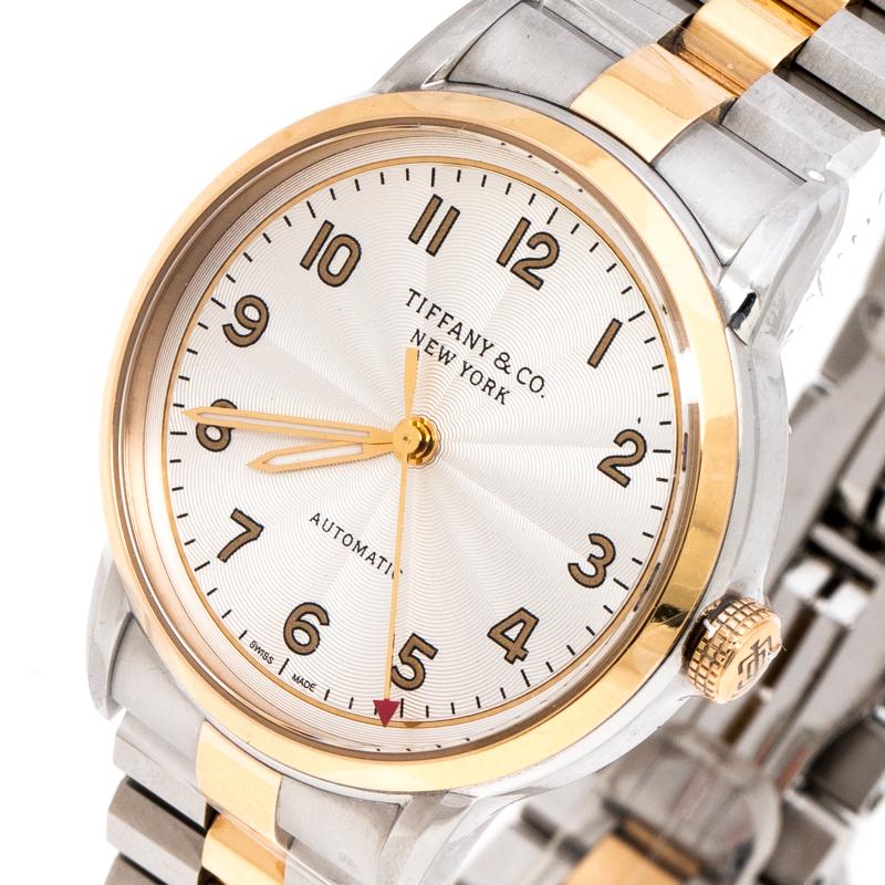 Tiffany & Co. nods to supreme elegance and charm with this watch that has a 34 mm, stainless steel case beautified with a gold-plated bezel. Its clean and smooth dial is fitted with Arabic numeral hour markers along with three gold-plated hands and