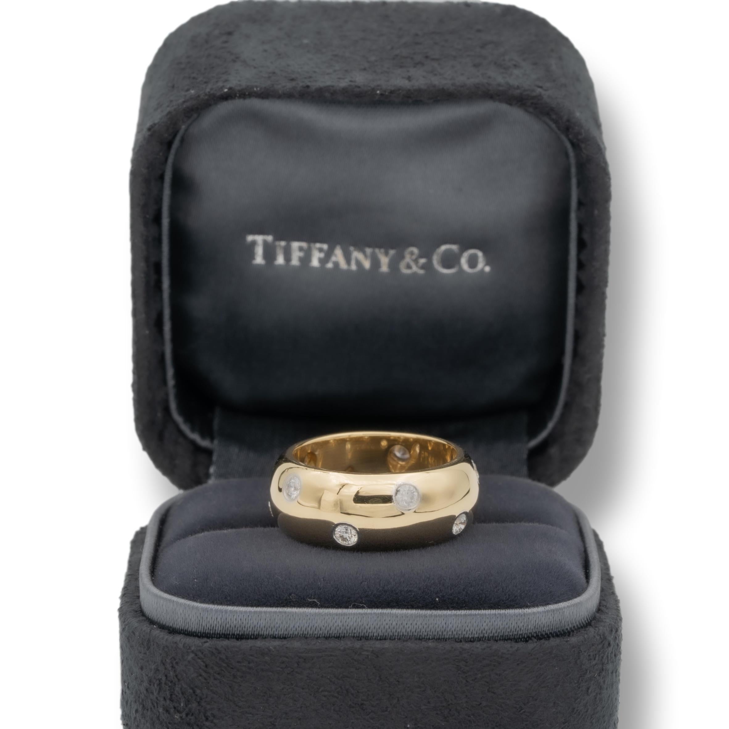 Tiffany & Co. Etoile Domed Band Ring finely crafted in 18 Karat yellow gold measuring 8mm wide with 10 round brilliant cut diamonds set in platinum bezels weighing 0.40 carats total weight approximately. The band is domed and comfort fit.

Stamp: