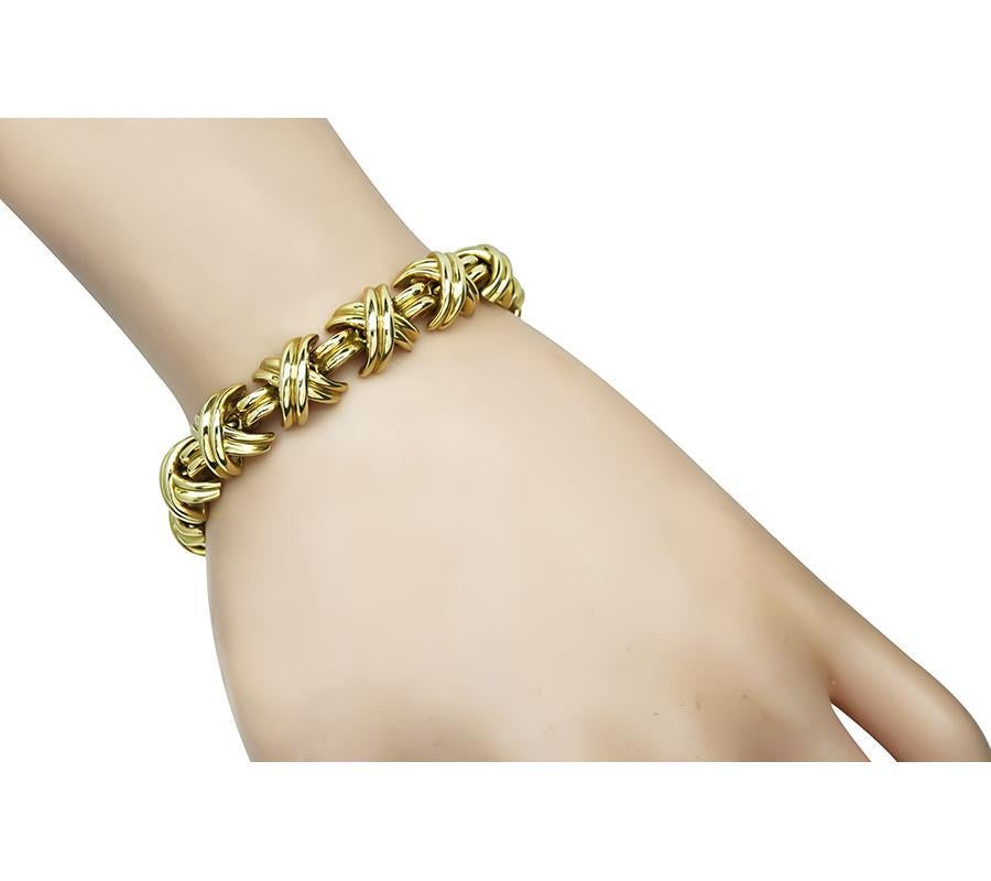 This is a charming 18k yellow gold bracelet by Tiffany & Co. The bracelet measures 7.25 inches in length and 10.5mm in width. The bracelet is signed T&Co. 750 and weighs 49.7 grams.