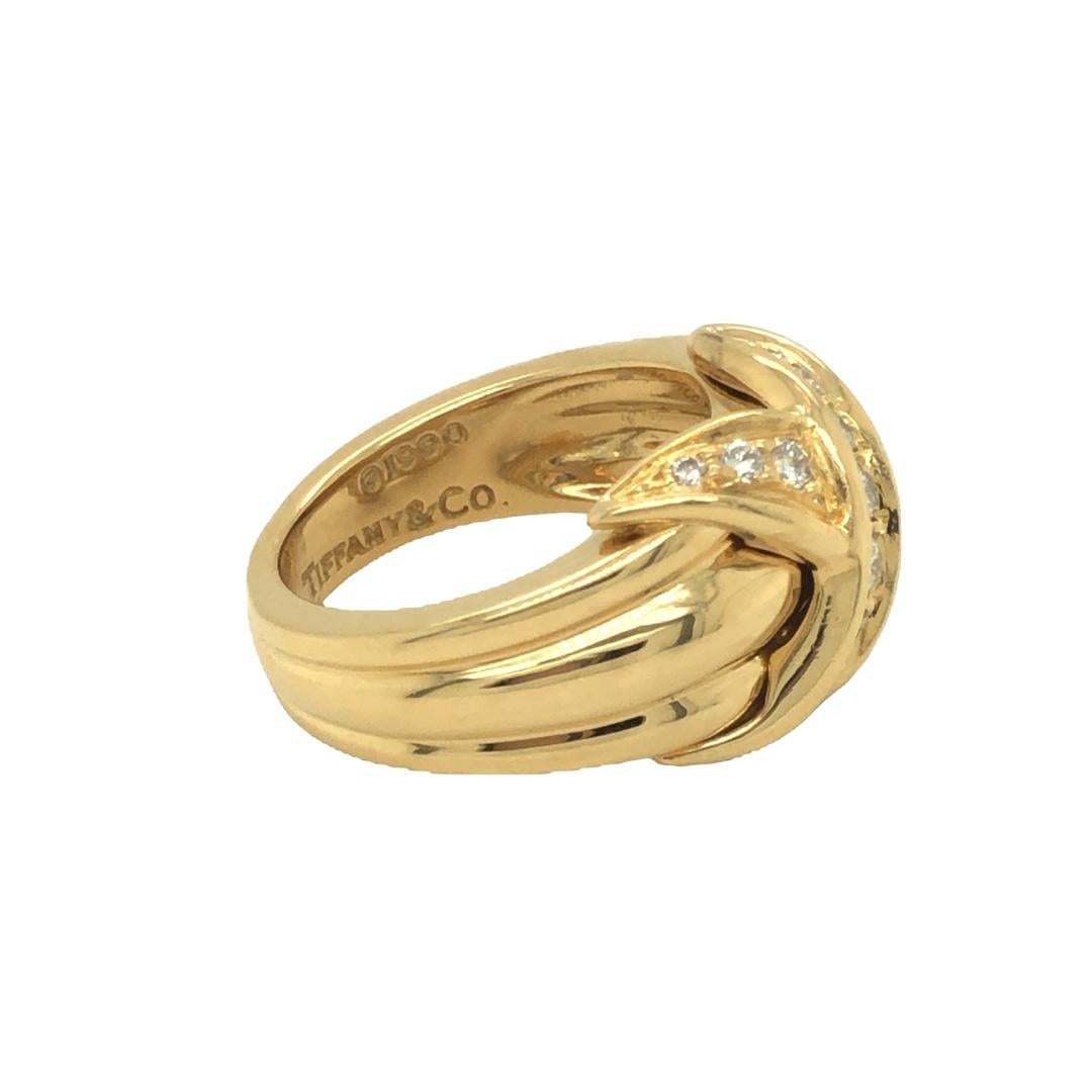 Tiffany & Co. 18K Yellow Gold Signature X Kiss ring. It features a sculpted in a grooved style and an X shape at the center with round brilliant cut diamonds weighing approx. 0.40 carat total weight. Production year 1990. Hallmarked Tiffany & Co.