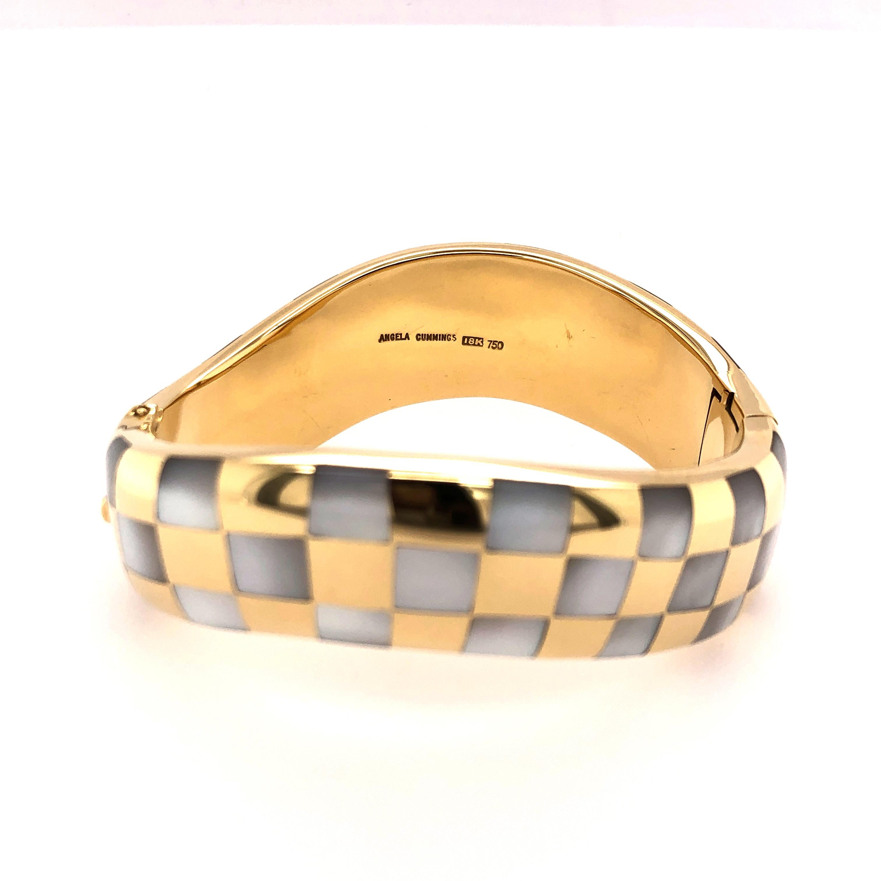 A wonderful collector's piece this bracelet from Angela Cummings is and exquisite piece of work. The inlaid Mother-of-Pearl creates a pleasant checker board pattern that follows the undulations of the bracelet. A mixture of strength and softness it