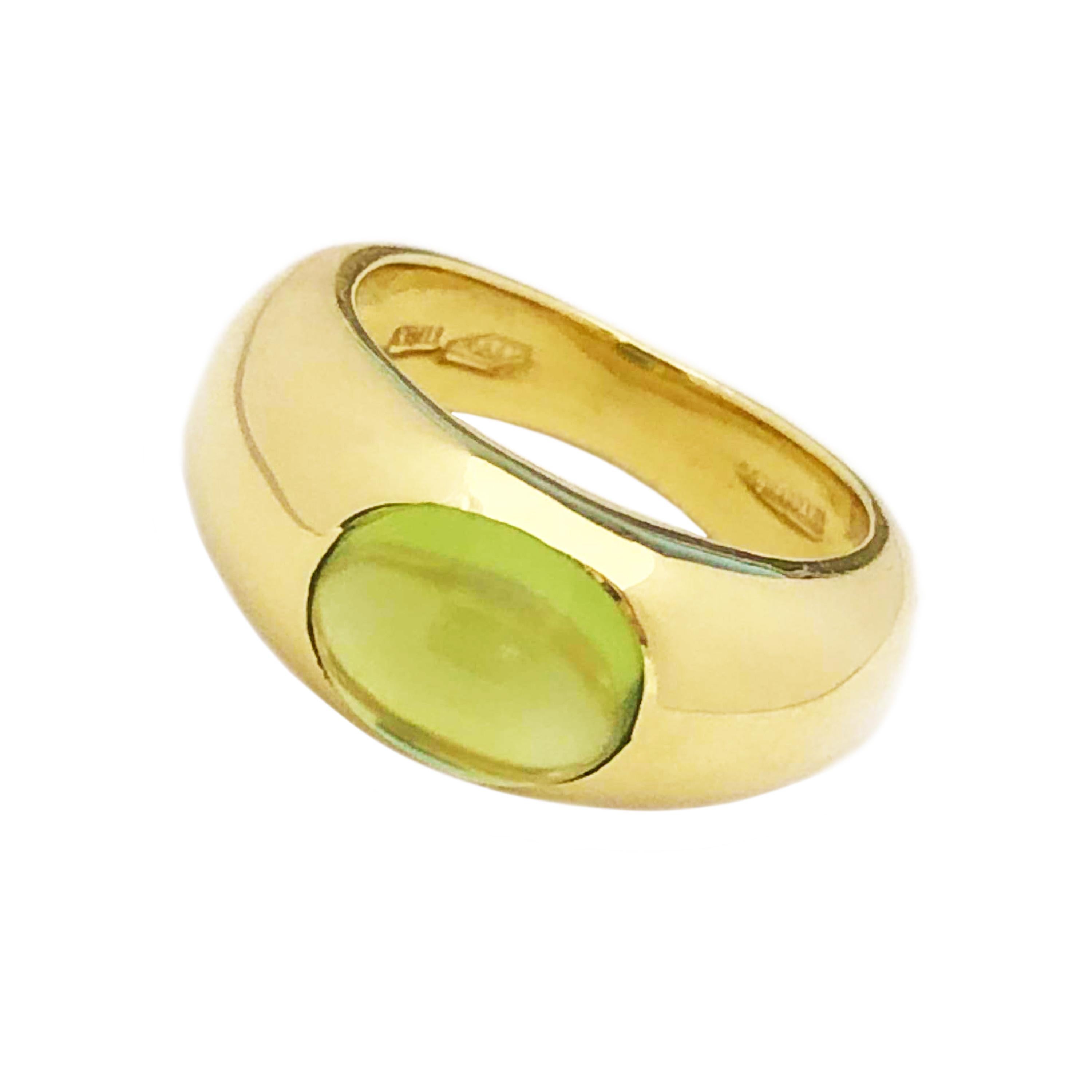 Circa 1970s Tiffany & Company 18K Yellow Gold Ladies Ring, centrally set with a fine color Oval Cabochon Peridot, measuring 8 X 6 MM approximately 2 Carats. Measuring 5/8 inch across the top and 1/4 inch wide. Finger size 4.  