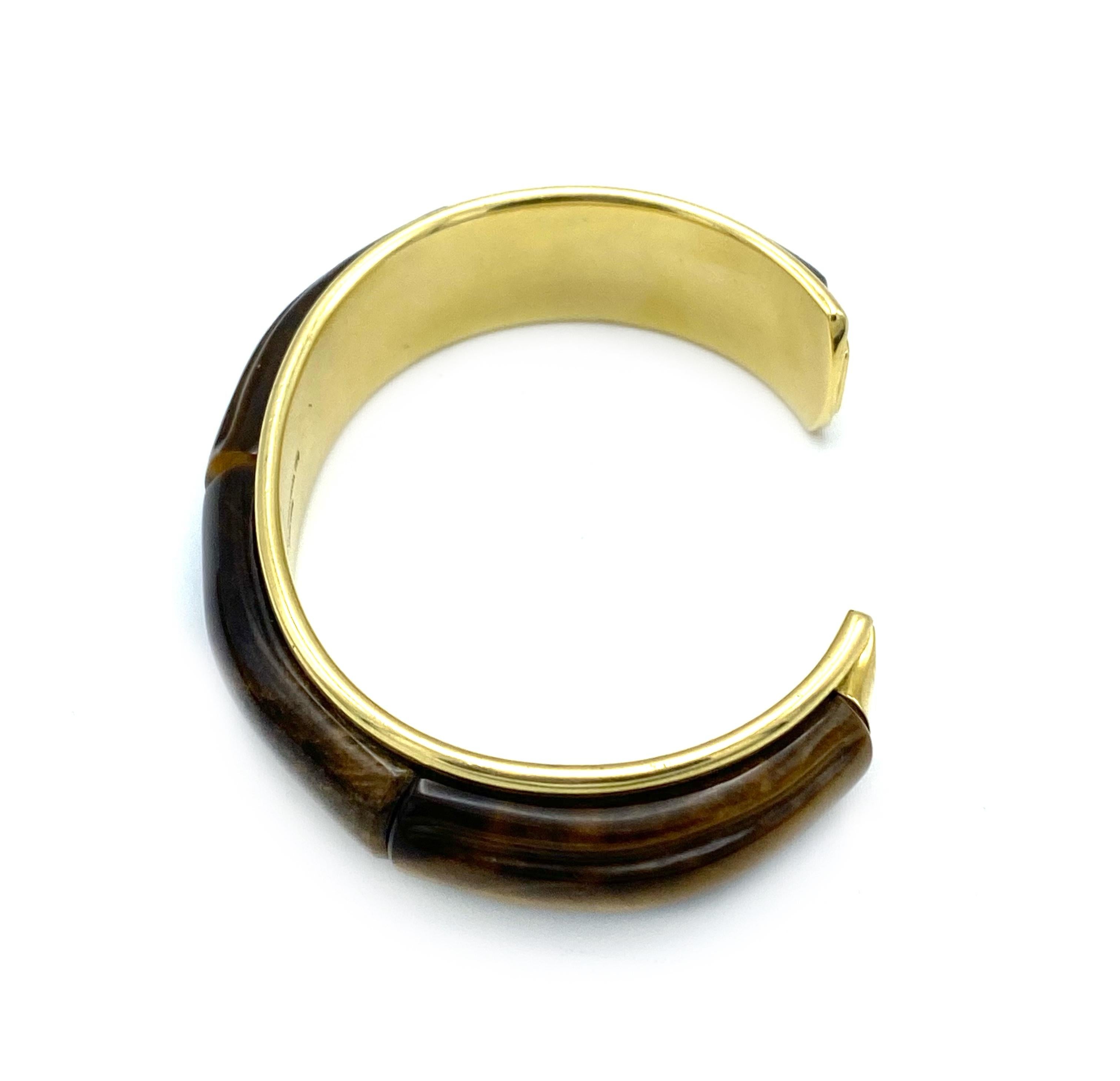 Product details:

The bangle is designed by Tiffany and Co. in 2002 in Hong Kong. It is made out of 18 karat yellow gold and detailed with tiger's eye accent. The bangle bits up to size 6.

Hallmarks: 2002 Tiffany & Co. 750 Hong Kong
Total weight is