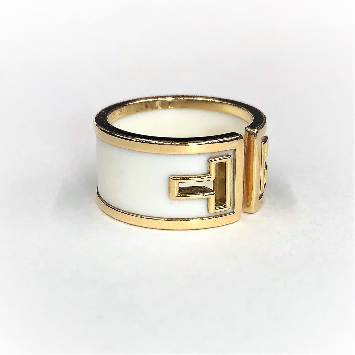 A ladies ring comprised of an 18K yellow gold frame with a white ceramic insert, and featuring gold rimmed 