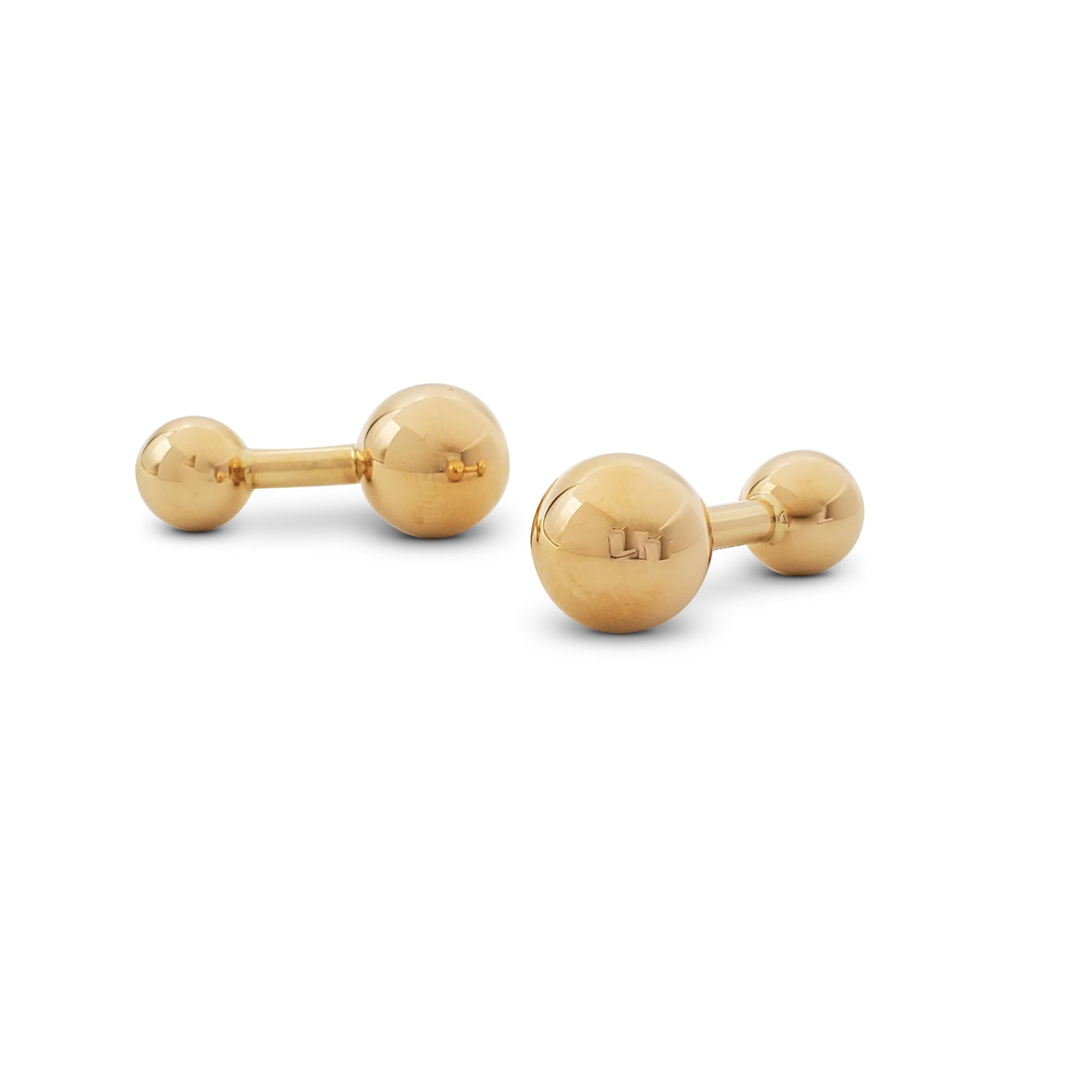 Authentic Tiffany & Co. barbell cufflinks crafted in 14 karat yellow gold. Signed Tiffany & Co., 14K. The larger barbell measures approximately 12 x 12 mm. The cufflinks are 29 mm in length. Not presented with the original box or papers. CIRCA