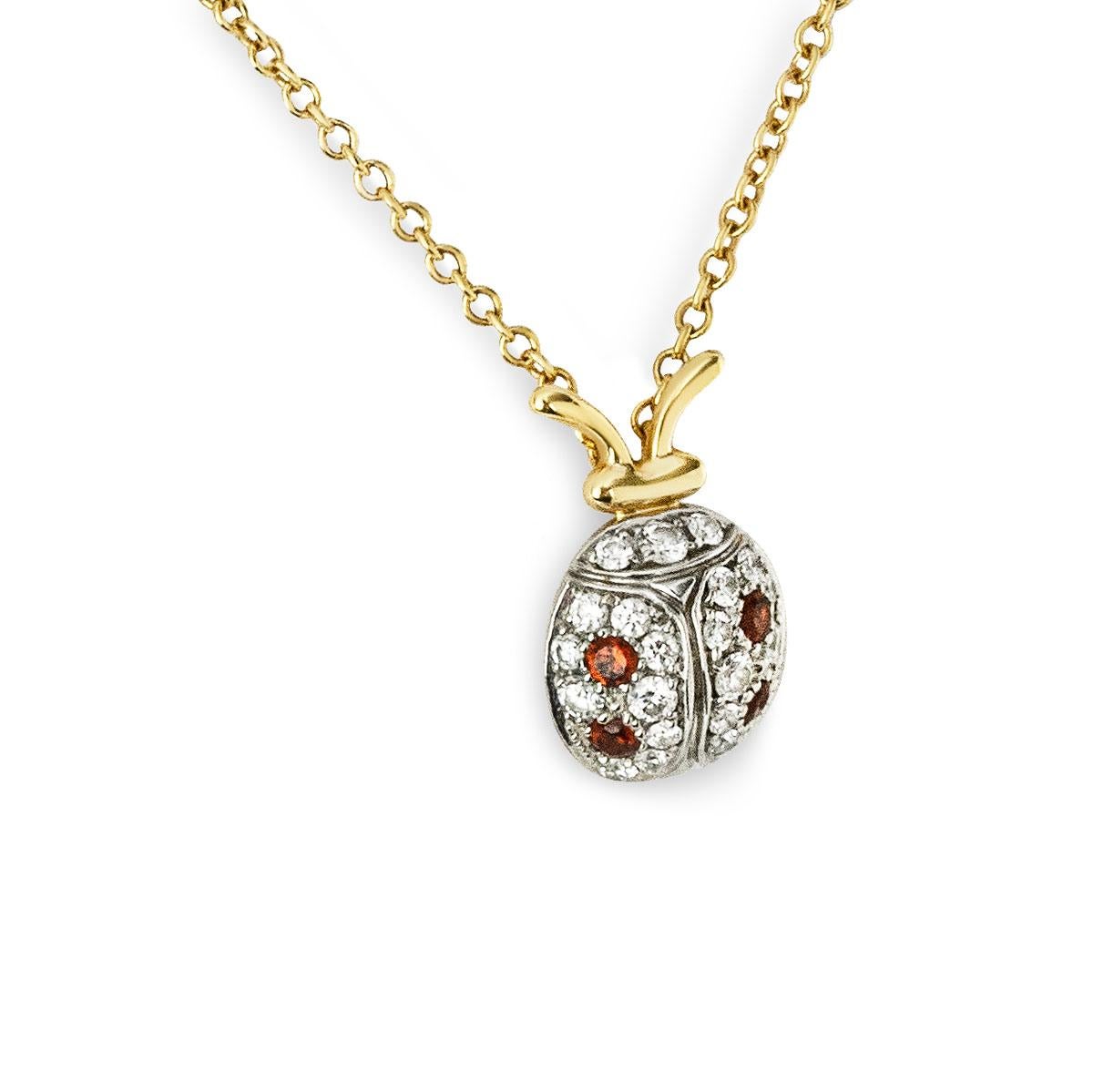 An 18k yellow gold and platinum Schlumberger Ladybug pedant by Tiffany & Co. The platinum Ladybug motif pendant is set with a total of 21 round brilliant cut diamonds, with a total diamond weight of approximately 0.13ct. 4 round cut garnets also