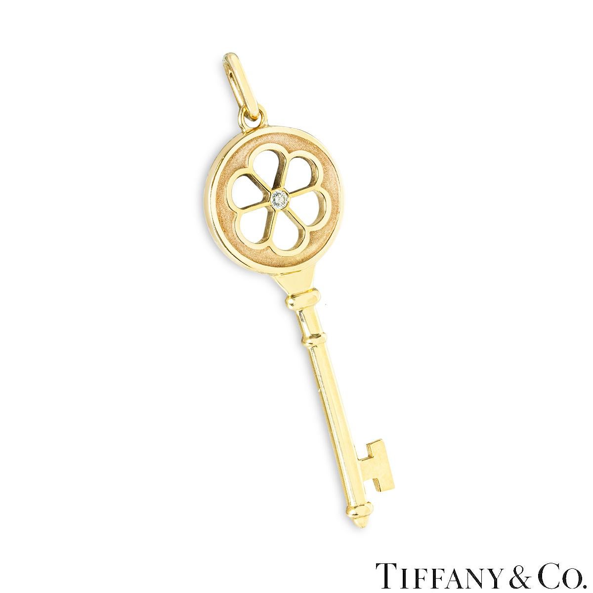Un bellissimo ciondolo a forma di fiore di diamante in oro giallo 18k di Tiffany & Co. della collezione Tiffany Keys. L'iconico ciondolo a forma di chiave presenta un motivo a fiore traforato con un singolo diamante rotondo taglio brillante. Il