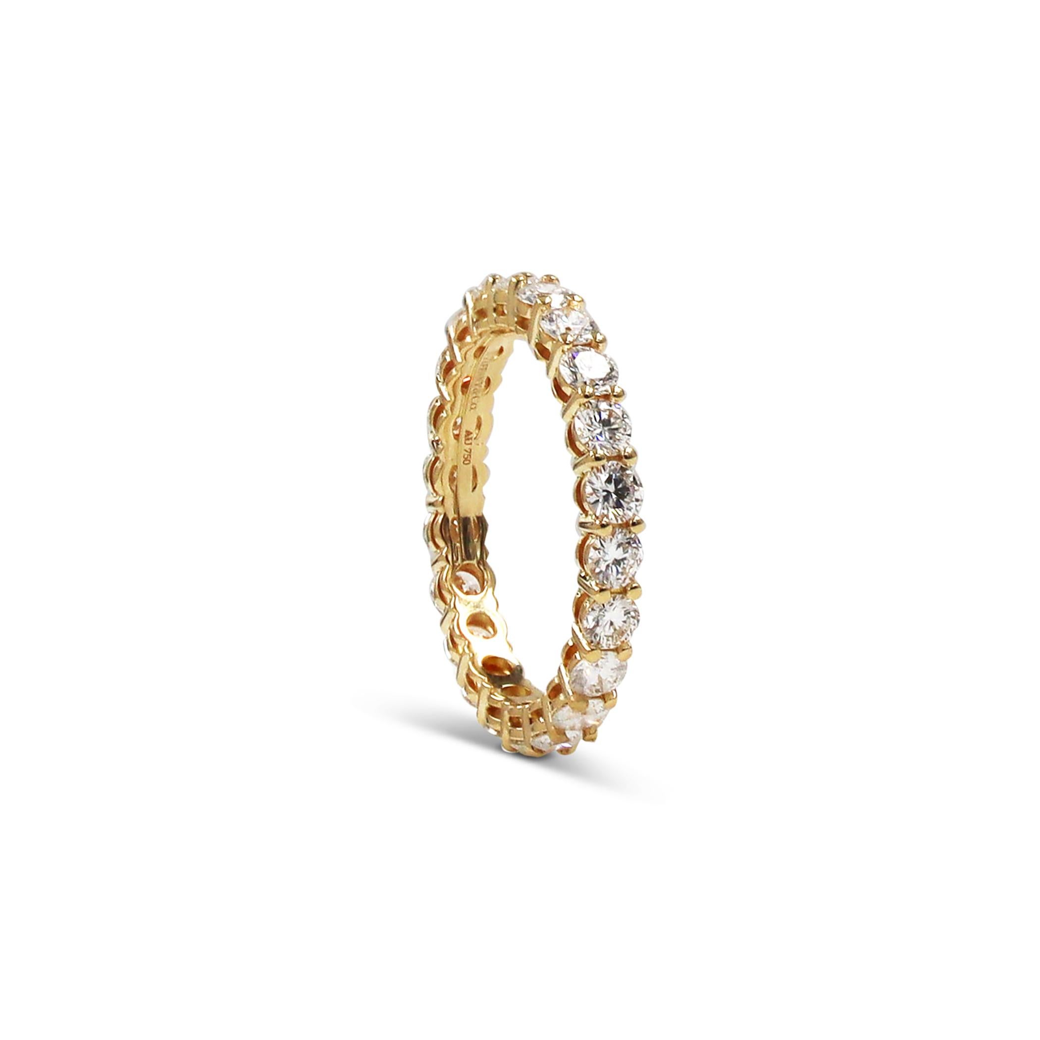 Authentic Tiffany & Co. eternity band crafted in 18 karat yellow gold. The shared prong setting features 22 stunning round brilliant diamonds for an estimated total weight of 2.22 carats (F-G color, VVS clarity). US size 7. Signed Tiffany & Co.,
