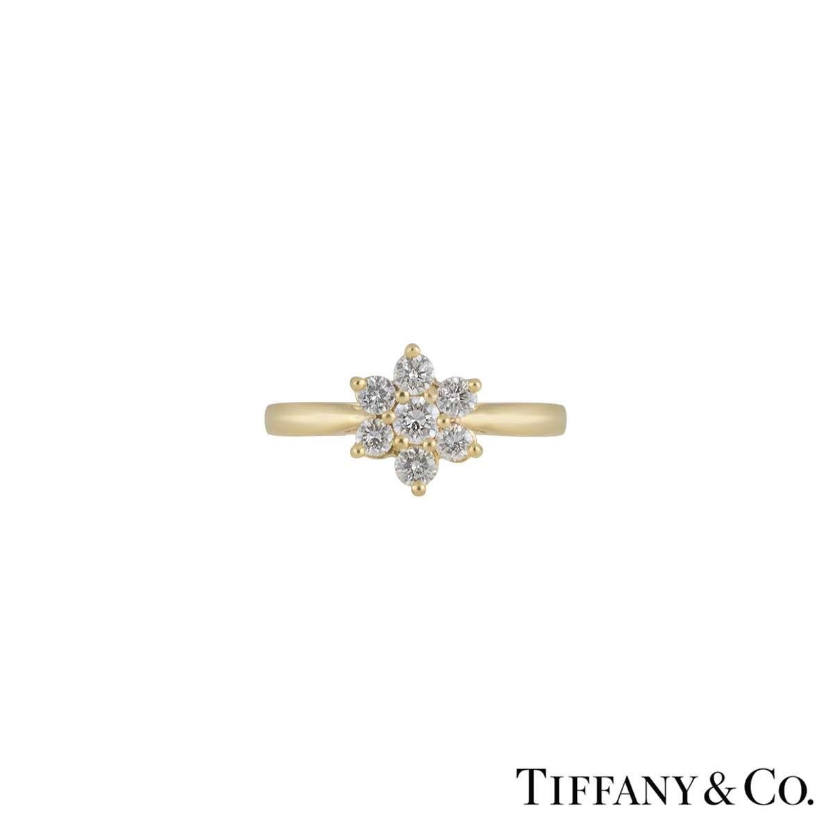 A unique Tiffany & Co 18k yellow gold diamond flower ring. This ring consists of a single round brilliant cut diamond for the centre with a further 6 round brilliant cut diamonds surrounding the outer edge, totalling approximately 0.47ct. The ring