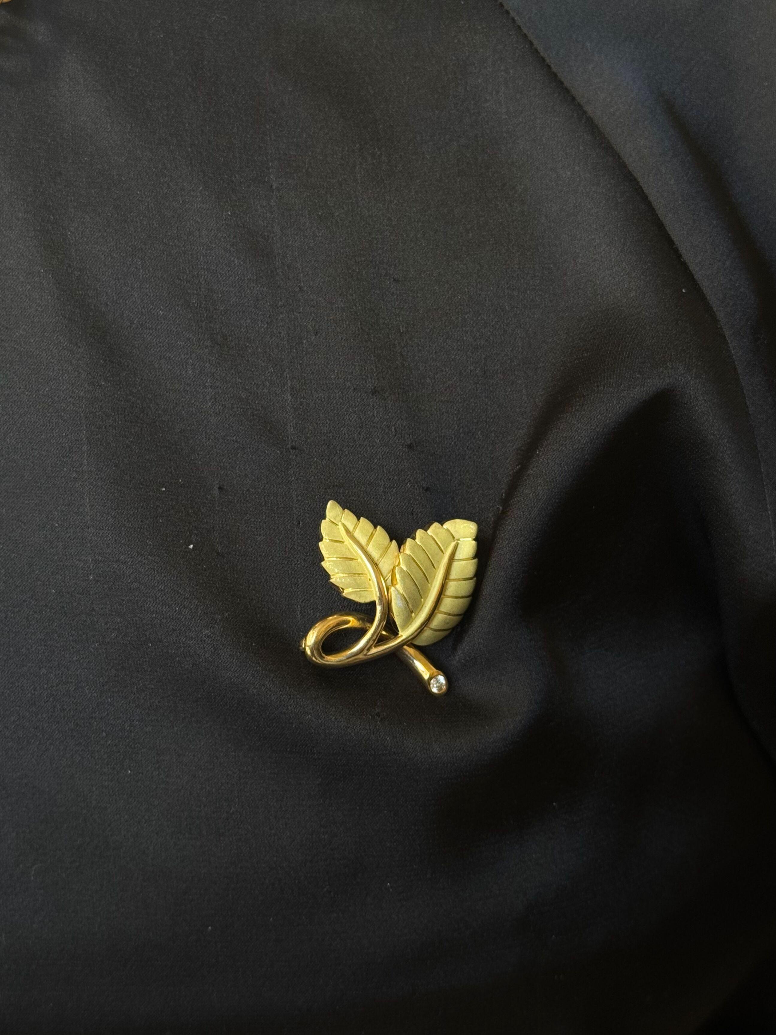 Broche de hoja de oro amarillo de 18 quilates con acabado cepillado, de Tiffany & Co., adornado con un diamante G/VS de aprox. 0,10 quilates. 
El broche mide 1 1/8