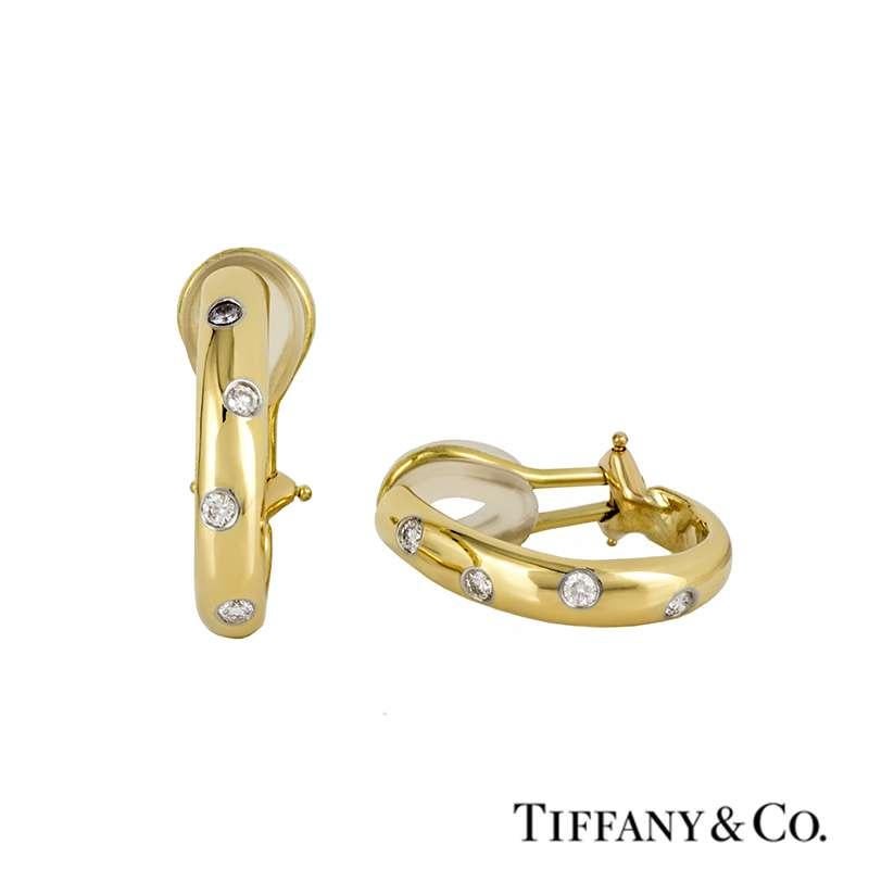 A pair of 18k yellow gold diamond set earrings from the Tiffany & Co Etoile collection. The hoop earrings are each intermittently set to the centre with four round brilliant cut diamonds totalling approximately 0.24ct, G/H in colour and VS in