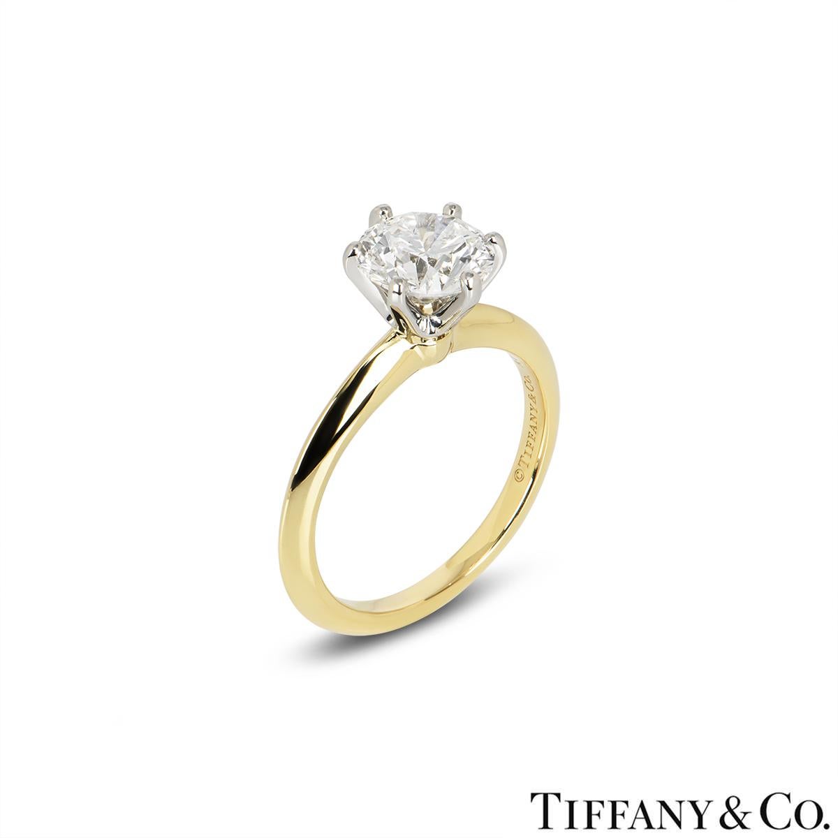 A stunning yellow gold diamond ring by Tiffany & Co. from the Setting collection. The ring comprises of a round brilliant cut diamond in a platinum six claw setting with a weight of 1.67ct, G colour and VVS1 clarity. The diamond scores an excellent