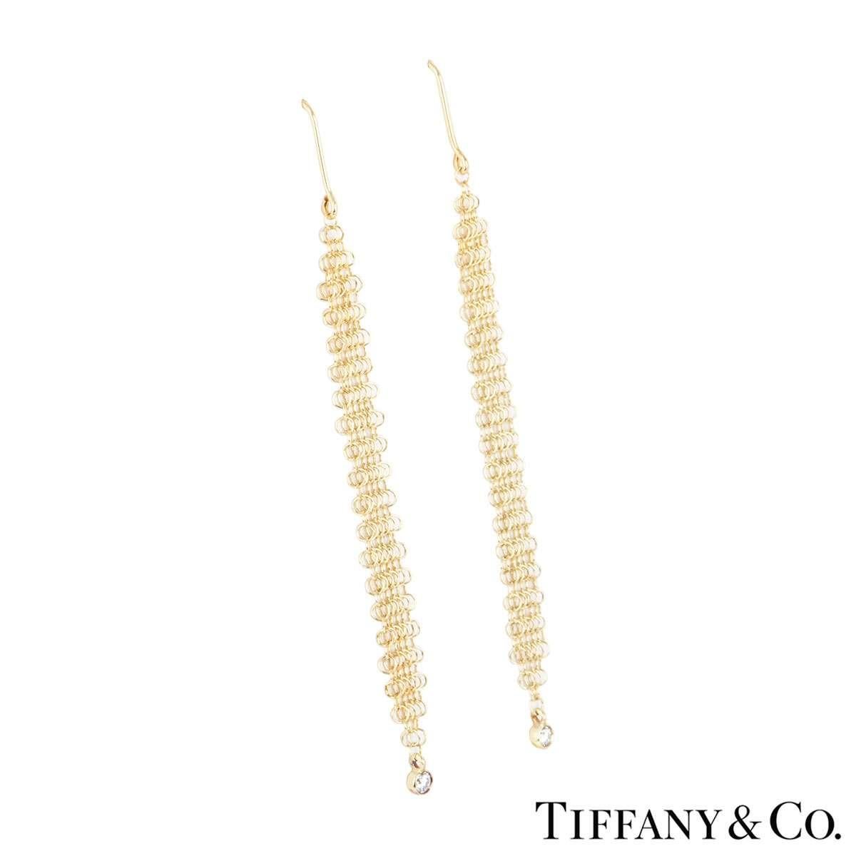 A pair of 18k yellow gold drop earrings from the Elsa Peretti collection by Tiffany & Co. The earrings are composed of a mesh body suspending a single round brilliant cut diamond at the bottom totalling 0.06ct. The earrings measure 6.5cm in length
