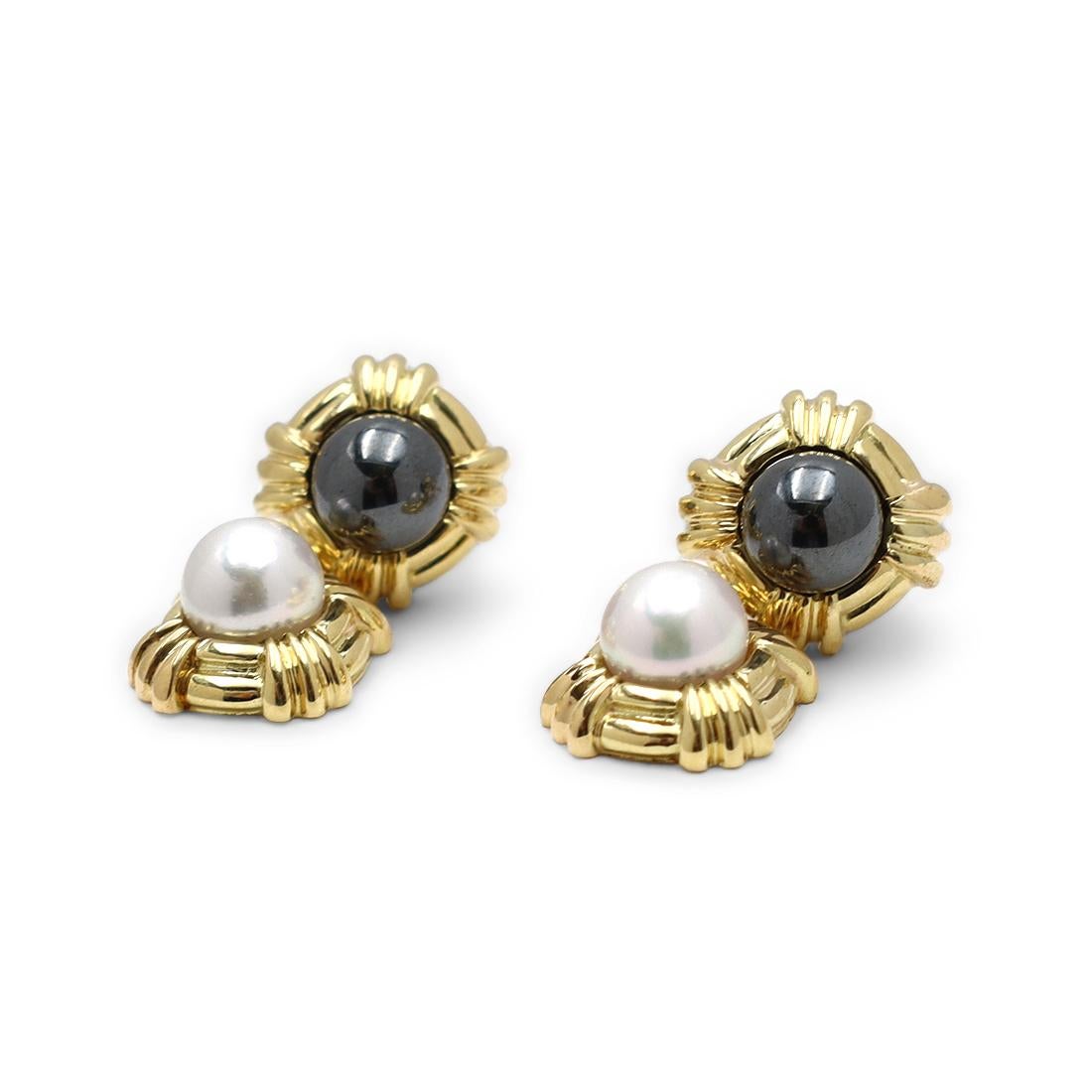 Authentic Tiffany & Co. earrings crafted in 18 karat yellow gold. A take on Tiffany & Co.'s iconic 'X' design, each earring features a 6.3mm pearl surrounded by a geometric gold frame, suspended from another frame centering on a hematite bead. The