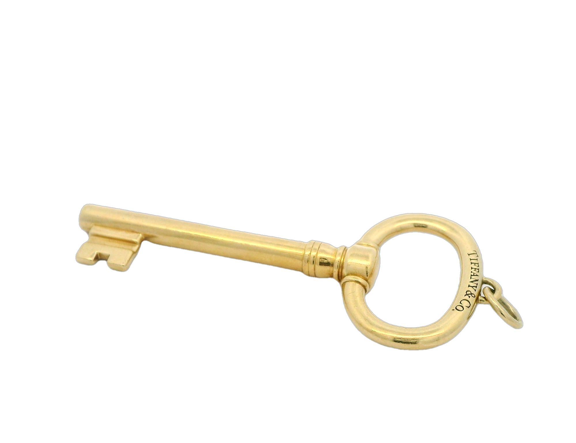 Tiffany & Co. yellow gold key pendant 

This exquisite gold key pendant from Tiffany & Co. is a symbol of elegance and sophistication. Crafted with precision, its sleek design makes it a timeless accessory for any occasion. Whether worn alone or
