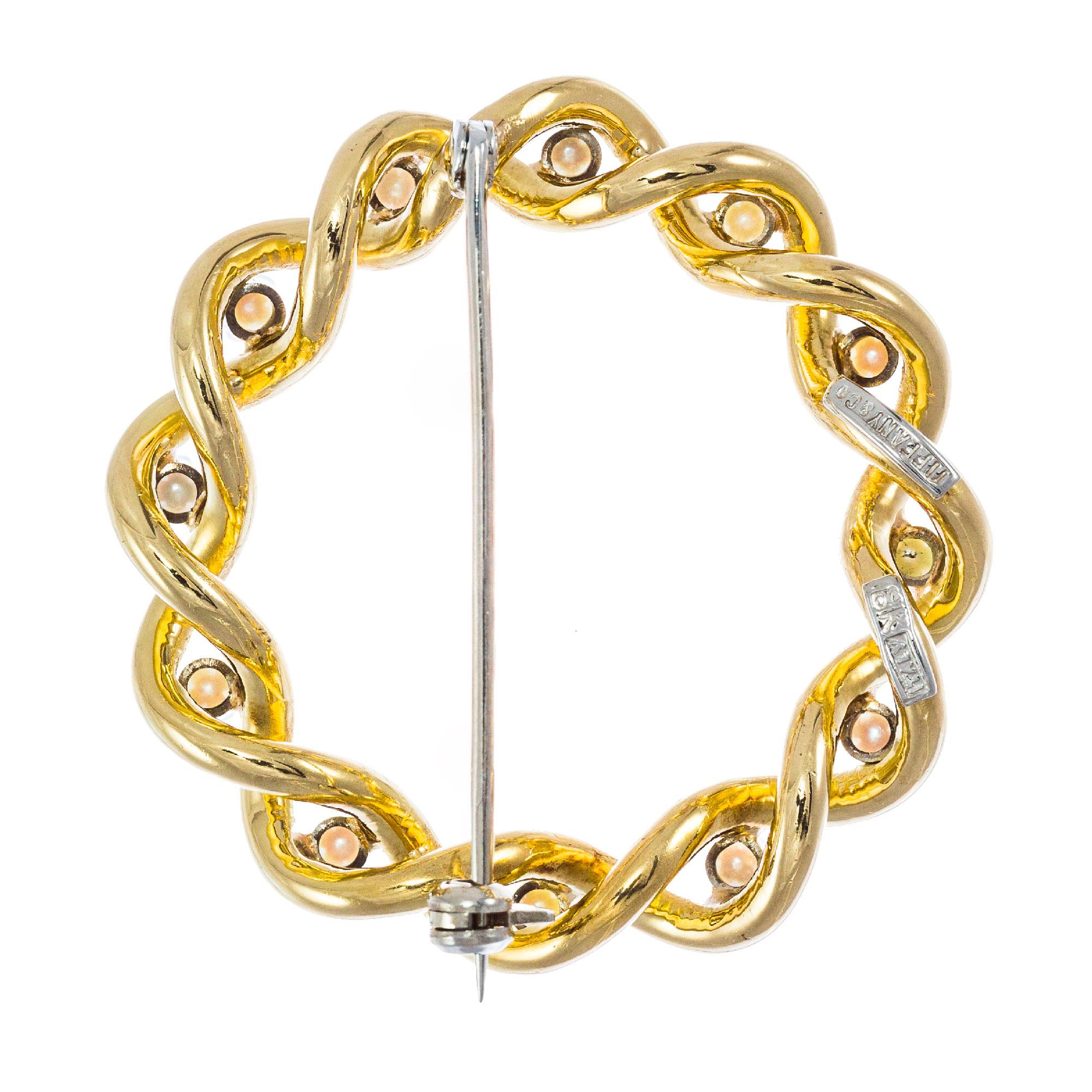 Tiffany & Co.  1960's 14k yellow brooch, set with 12 Akoya cultured pearls in a woven design. Made in Italy.

12 Japanese Akoya cultured pearls 2-2.5mm
Top to bottom: 35.39mm or 1.39 inches
Width: 35.96mm or 1.42 inches
Depth or thickness: