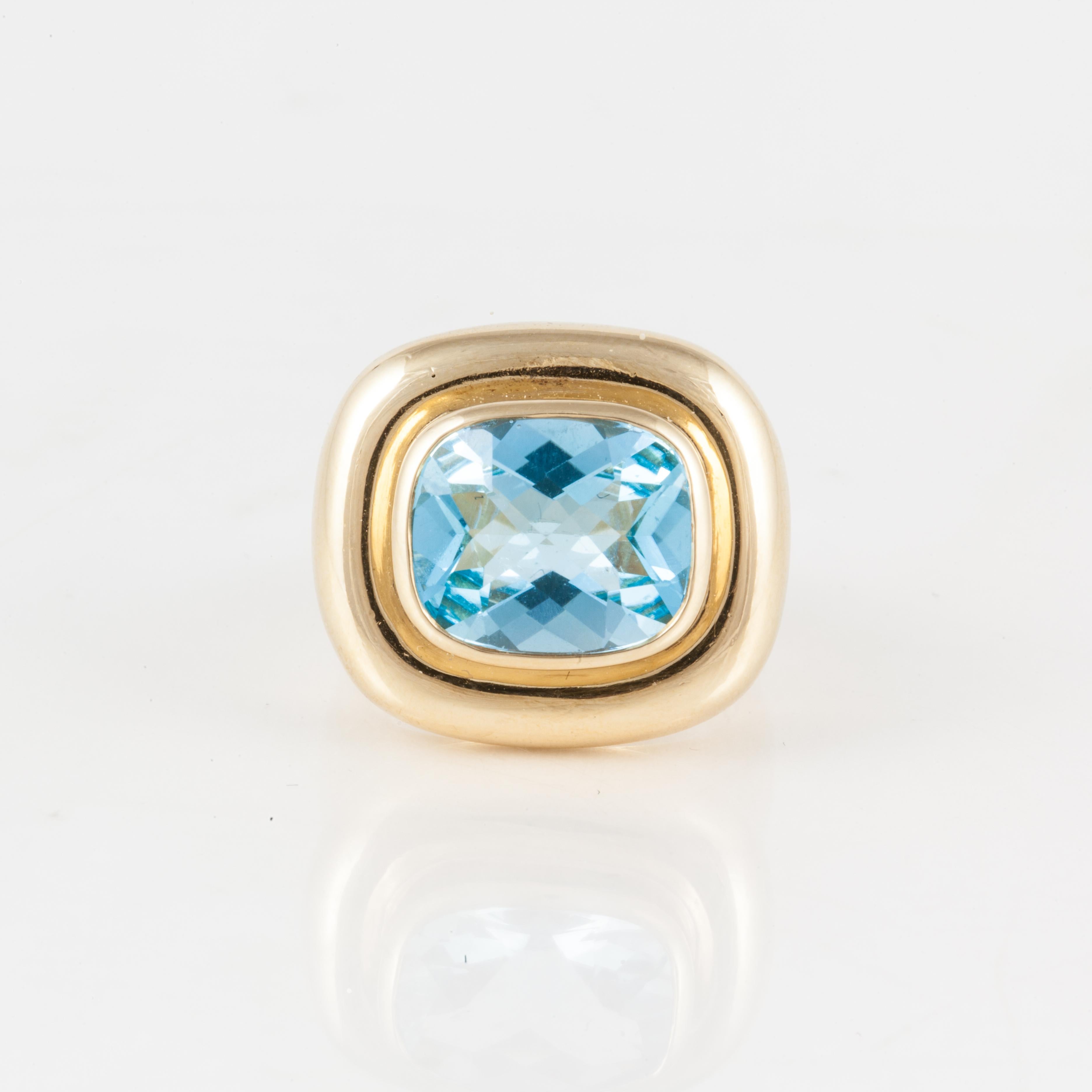 18K yellow gold ring by Paloma Picasso for Tiffany, featuring a cushion-cut blue topaz which totals 6.50 carats.  Presentation area measures 3/4 of an inch by 11/16 of an inch.  The ring is currently a size 5.