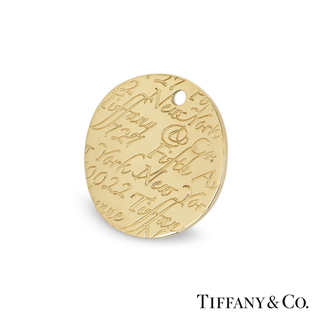 Pendentif en or jaune 18 carats de Tiffany & Co. de la collection Notes. Le pendentif circulaire au design ondulé est gravé d'une élégante écriture indiquant Tiffany & Co 727 Fifth Avenue 10022. Le pendentif mesure 2,4 cm et pèse 9,23 grammes.

Le