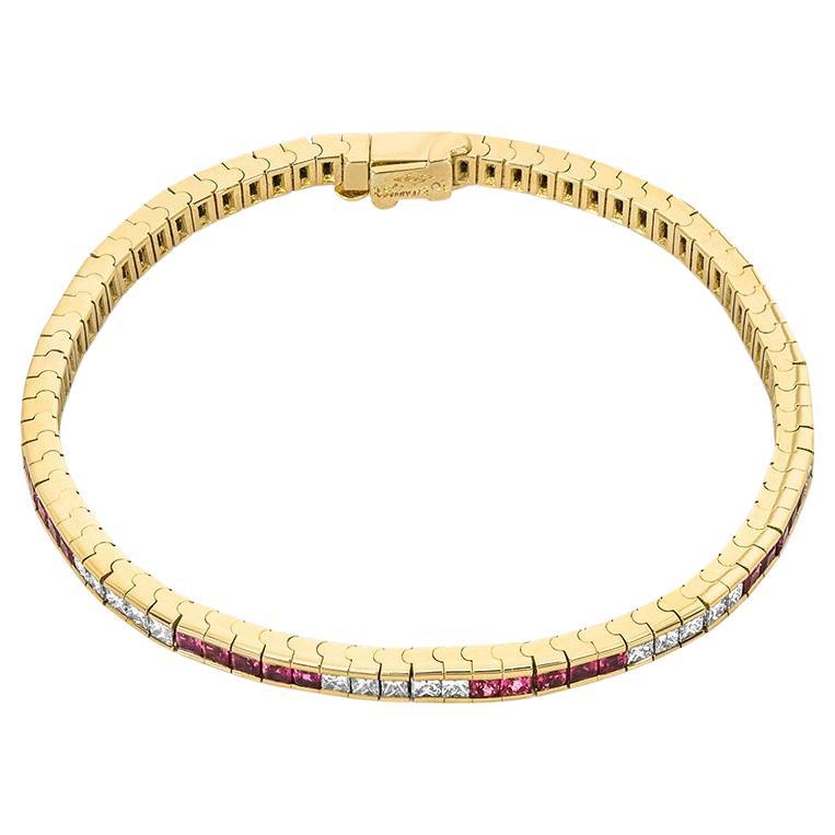A marvellous 18k yellow gold ruby and diamond tennis bracelet from Tiffany & Co. The line bracelet alternates between rubies and diamonds in a channel setting. There are 40 princess cut rubies with an approximate total weight of 4.51ct displaying a