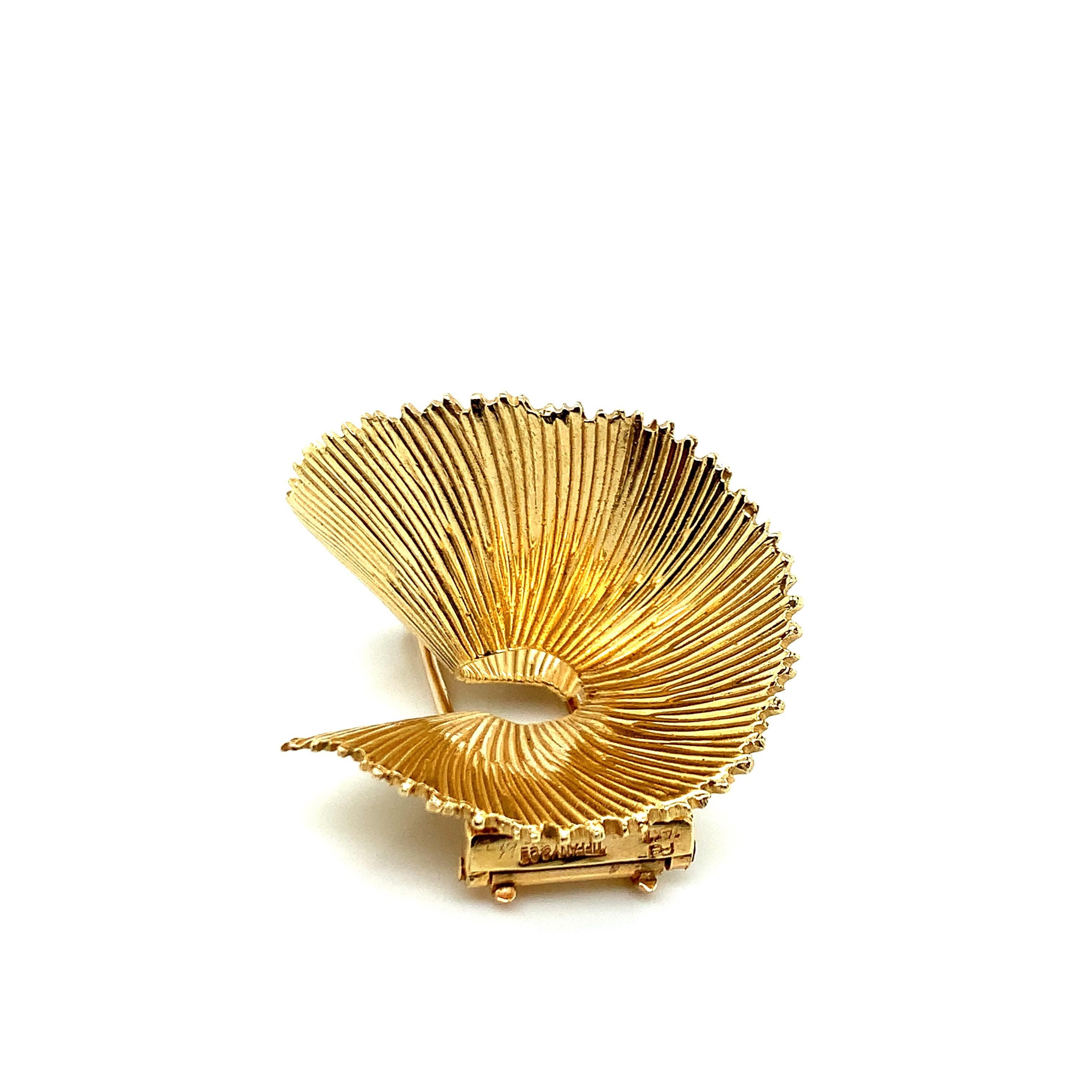 Tiffany & Co. 14 karat yellow gold dress clip in the form of the letter S. It has a fan like design and comes in a branded box. Marked: 14kt / Tiffany & Co. Total weight: 17.6 grams. Width: 4.1 cm. Length: 3.4 cm. 